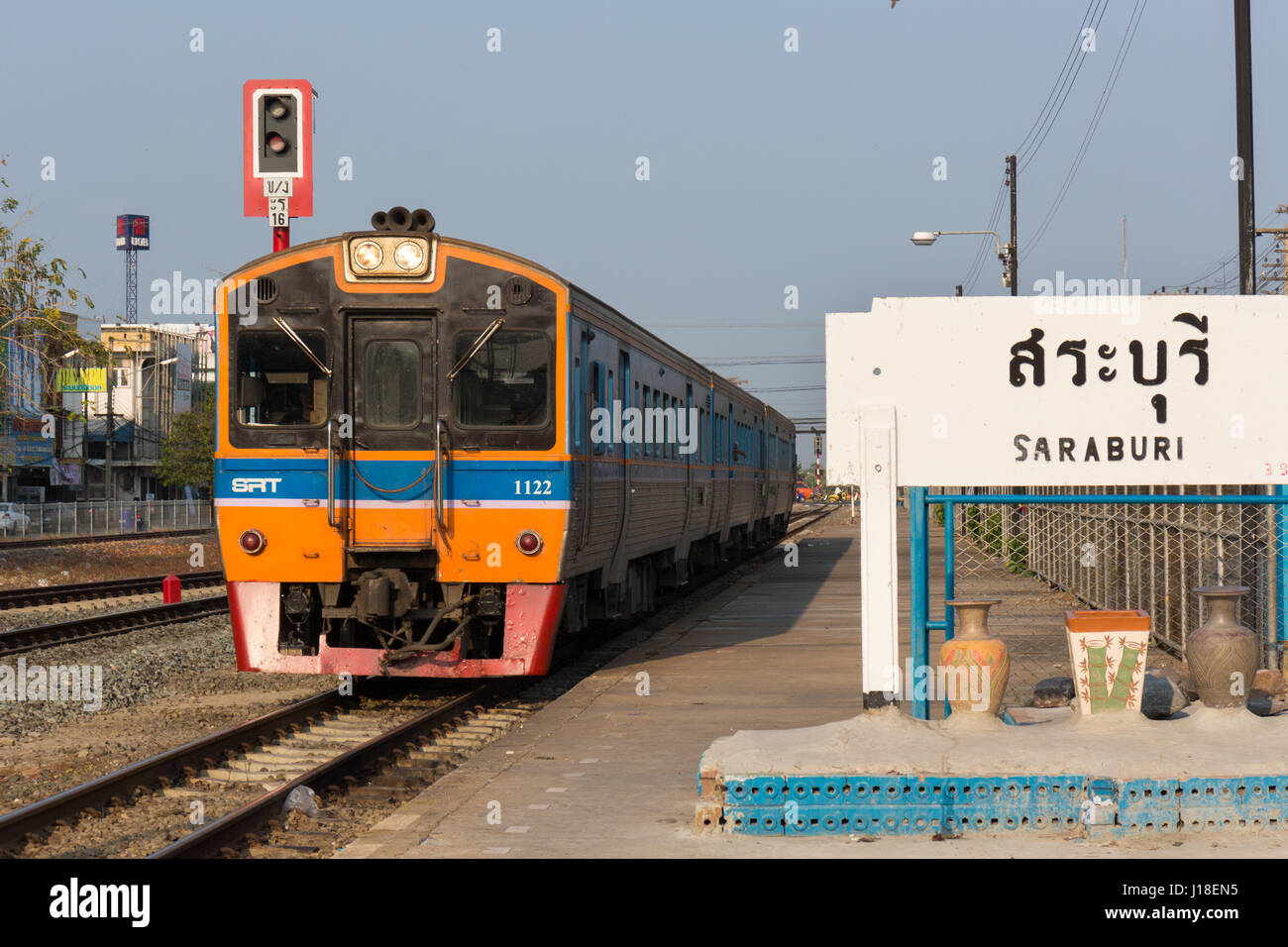 Diesel passenger train arriving at Saraburi railway station, Thailand Stock Photo
