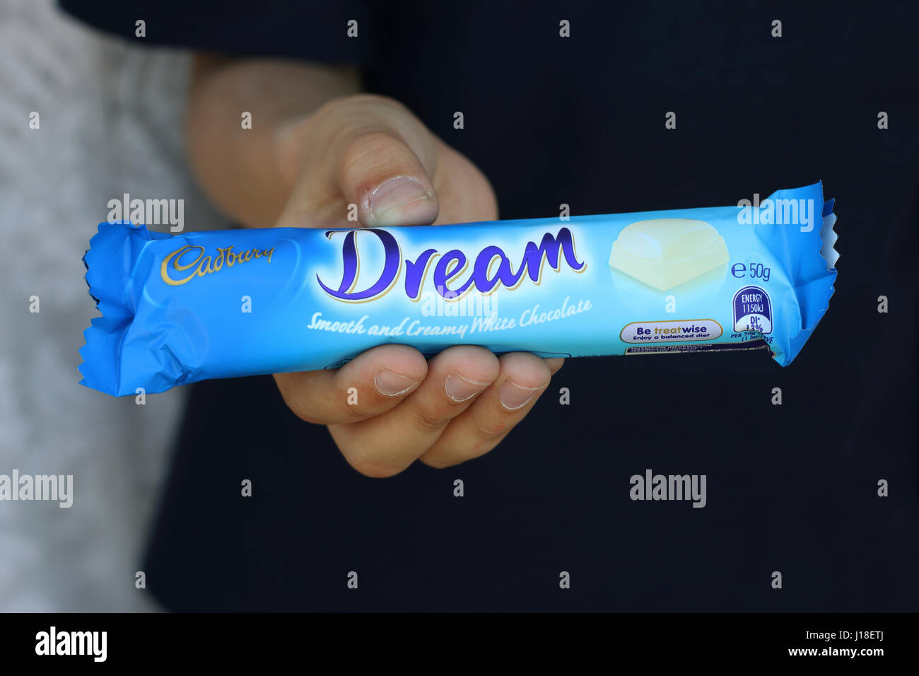 Hand holding Australia Cadbury white chocolate bar isolated Stock Photo