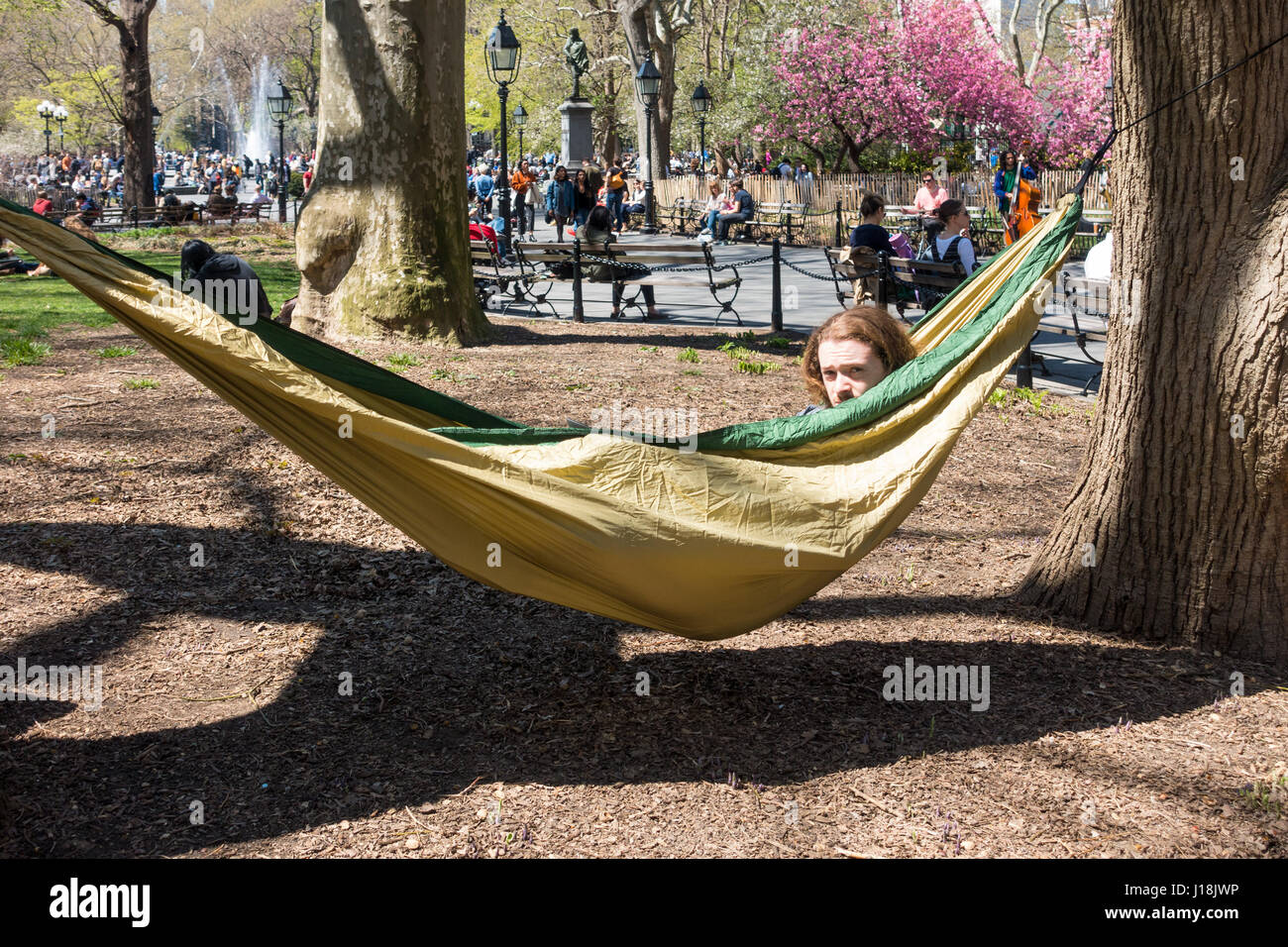 A young man relaxing in a hammock in Washington Square Park in New York