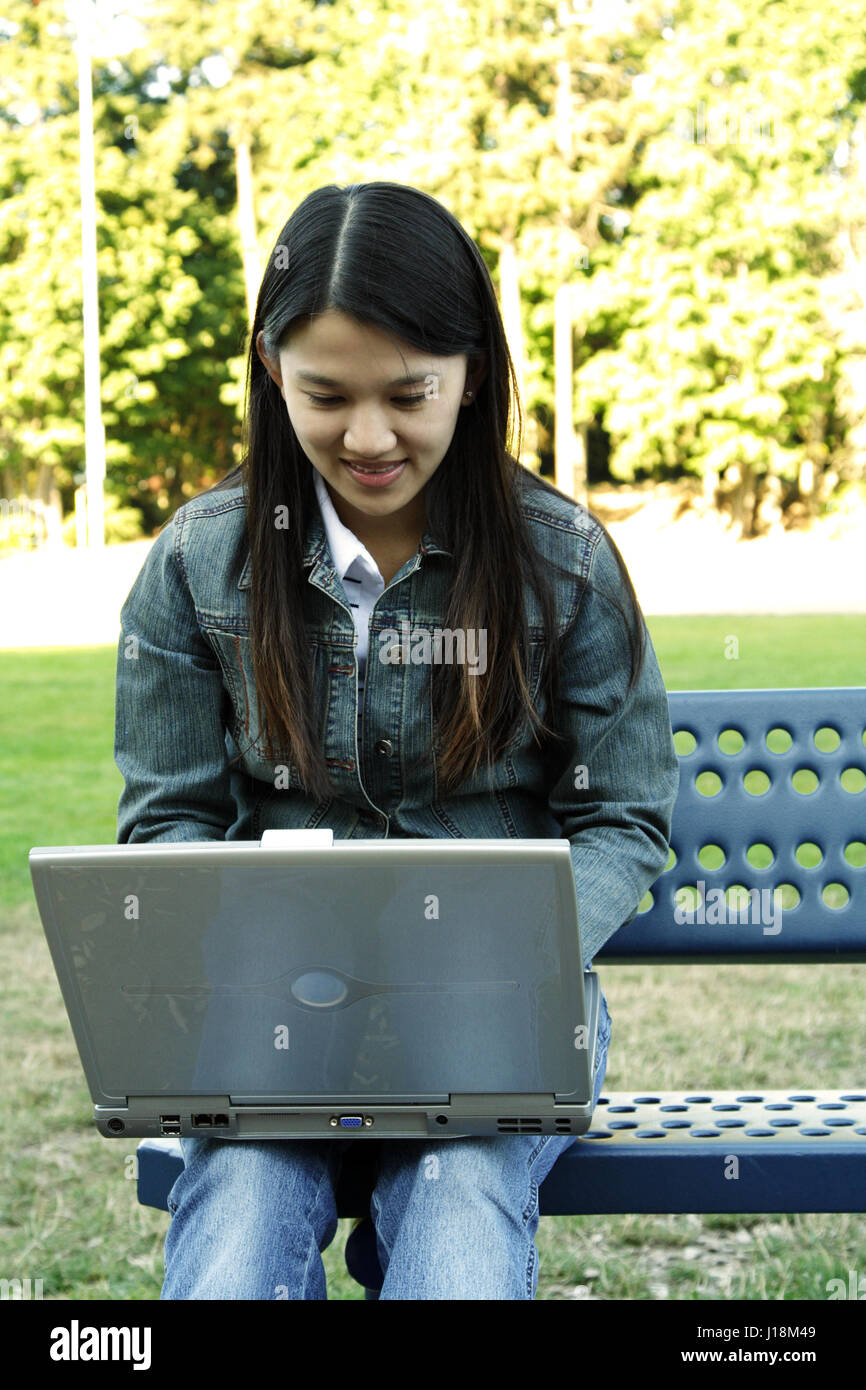 A girl working with her laptop in a park Stock Photo - Alamy