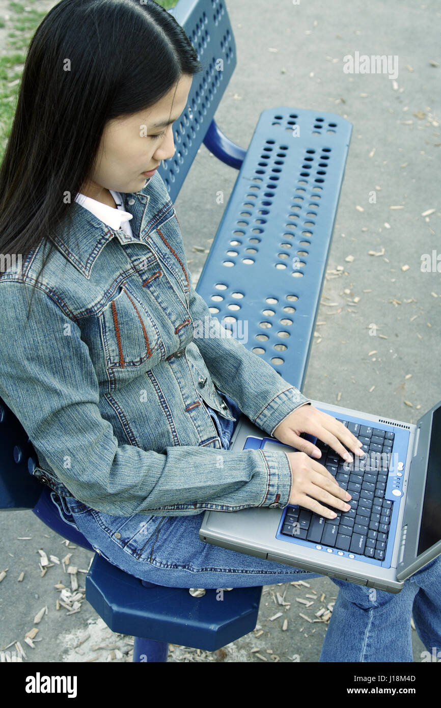 A girl working on her laptop at a park Stock Photo - Alamy