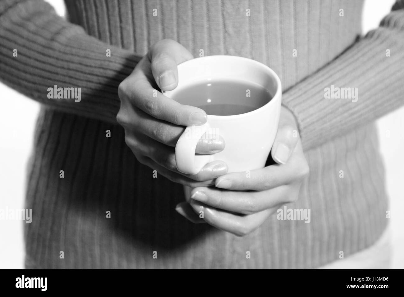 A woman holding a coffee cup (in black and white) Stock Photo