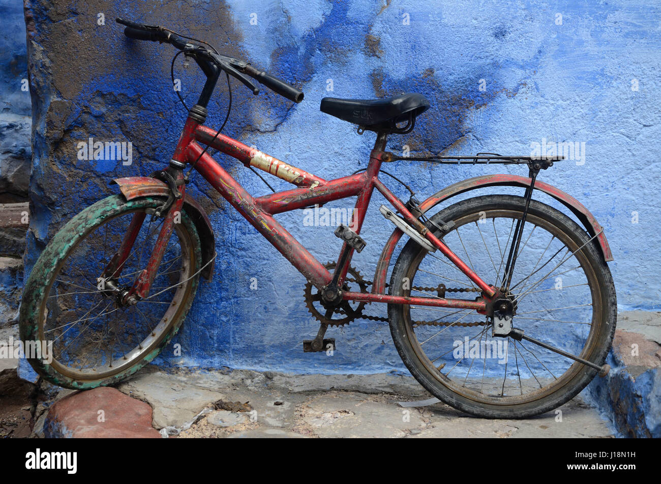 Red bicycle in front of blue house wall jodhpur rajasthan india asia Stock Photo Alamy