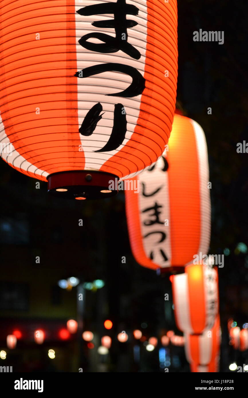 Japanese lanterns in Tokyo lit up orange in close-up against a black sky Stock Photo