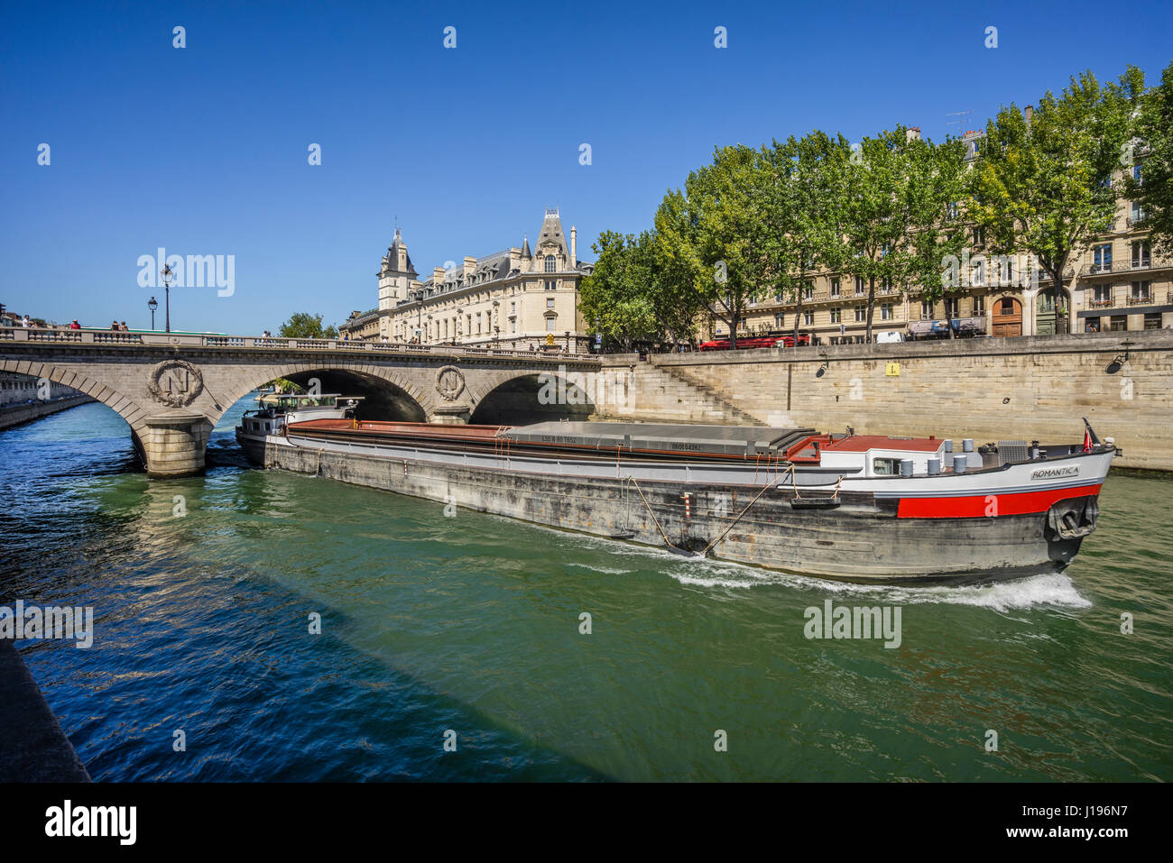 France, Paris, Seine, Ile de la Cite, a freight barge is passing under Petit Pont Stock Photo