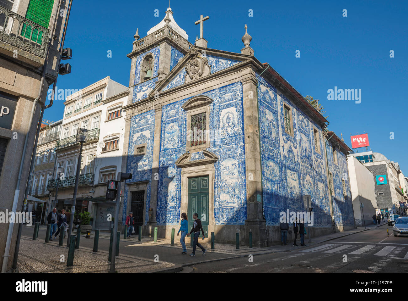 Capela Das Almas Porto, tourists walk past the blue azulejos clad exterior of the Capela Das Almas in the Bolhao area of central Porto (Oporto). Stock Photo