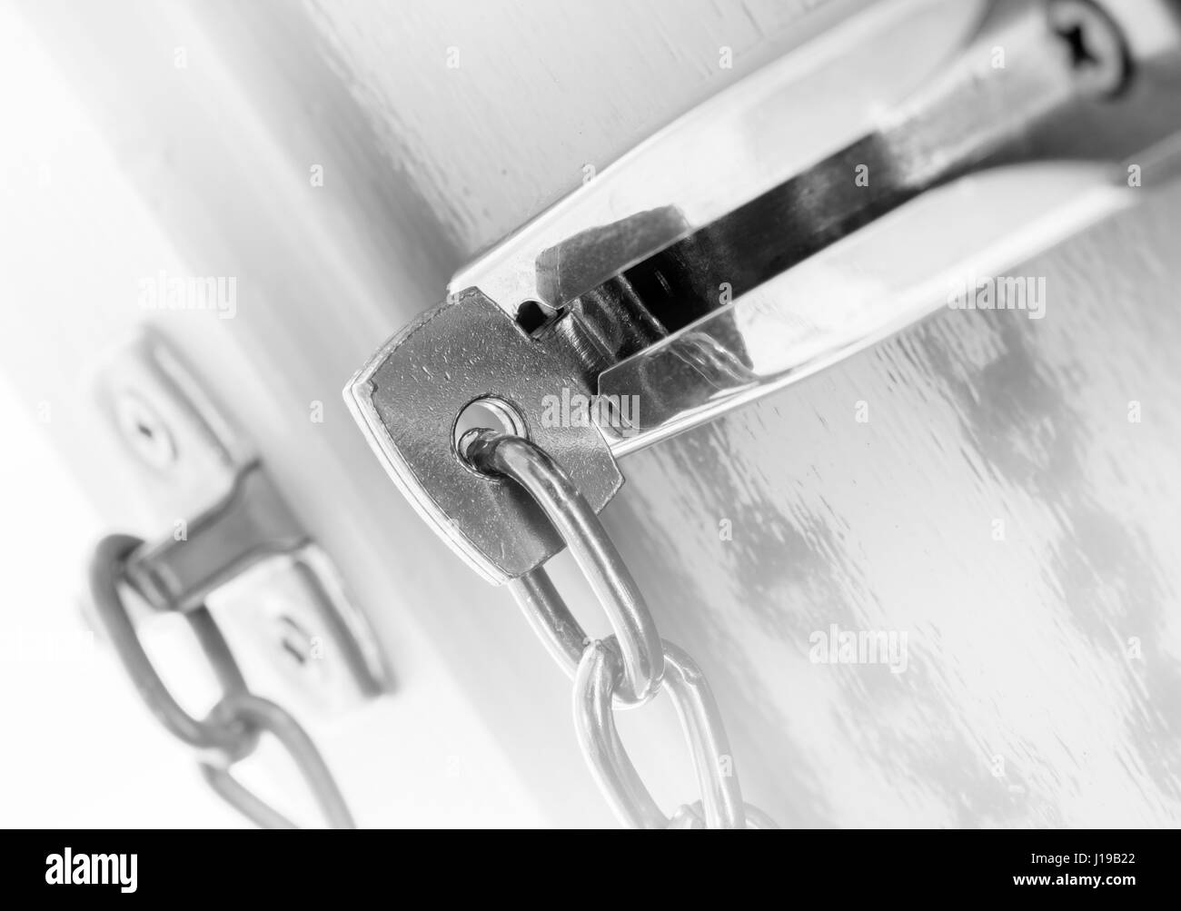 Door chain on a grey door, security measures Stock Photo