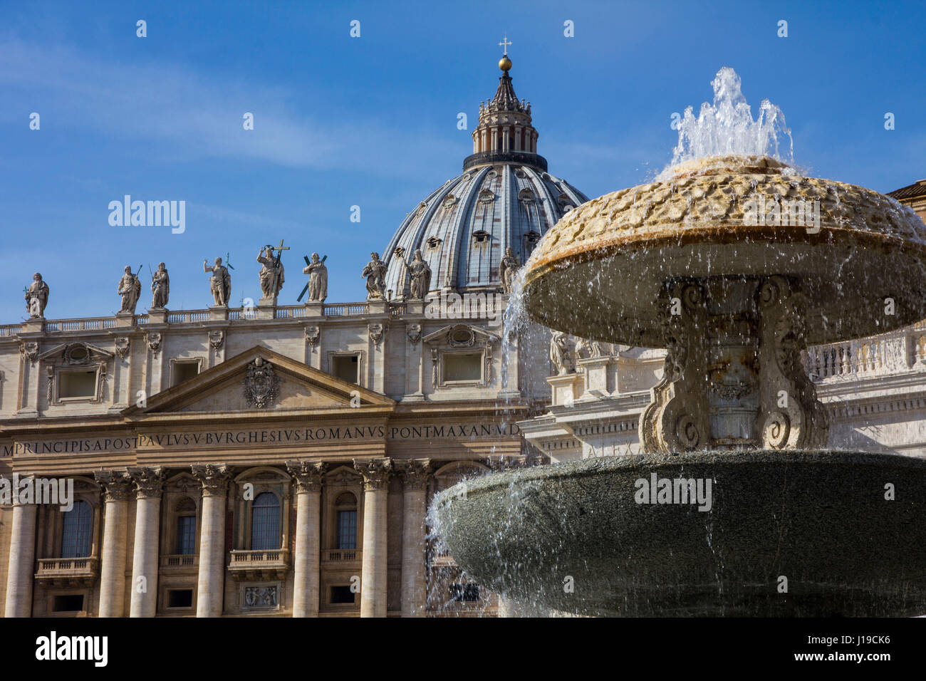 A view of St. Peter's Basilica, with the 1613 marble fountain of Carlo Maderno in the foreground, on St. Peter's Square, Vatican City, Rome, Italy. Stock Photo