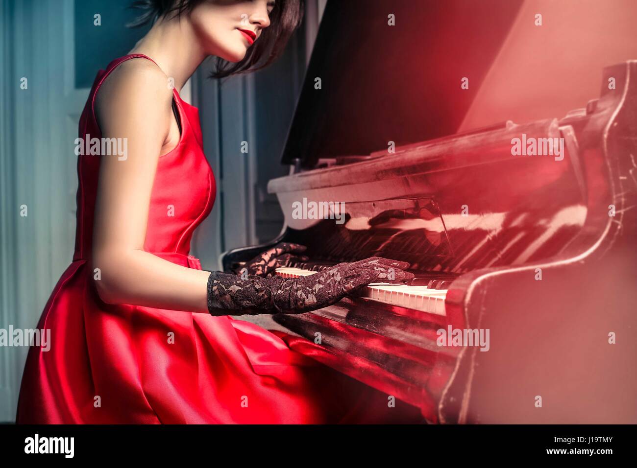 Detail of a woman wearing a beautiful red dress and playing the piano Stock  Photo - Alamy