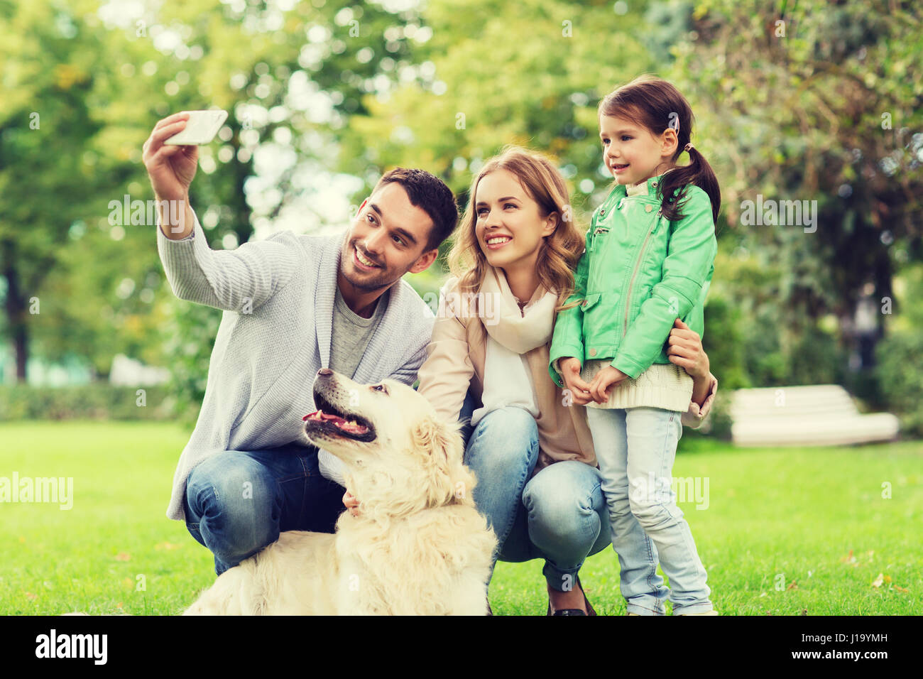 happy family with dog taking selfie by smartphone Stock Photo