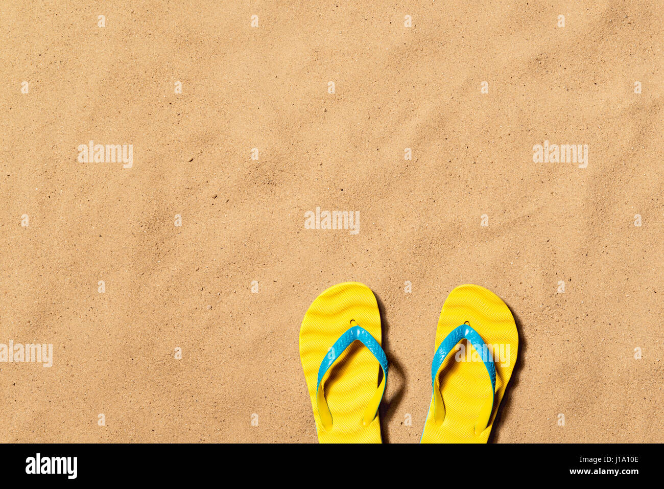 Summer vacation composition with a pair of yellow flip flop sandals on ...