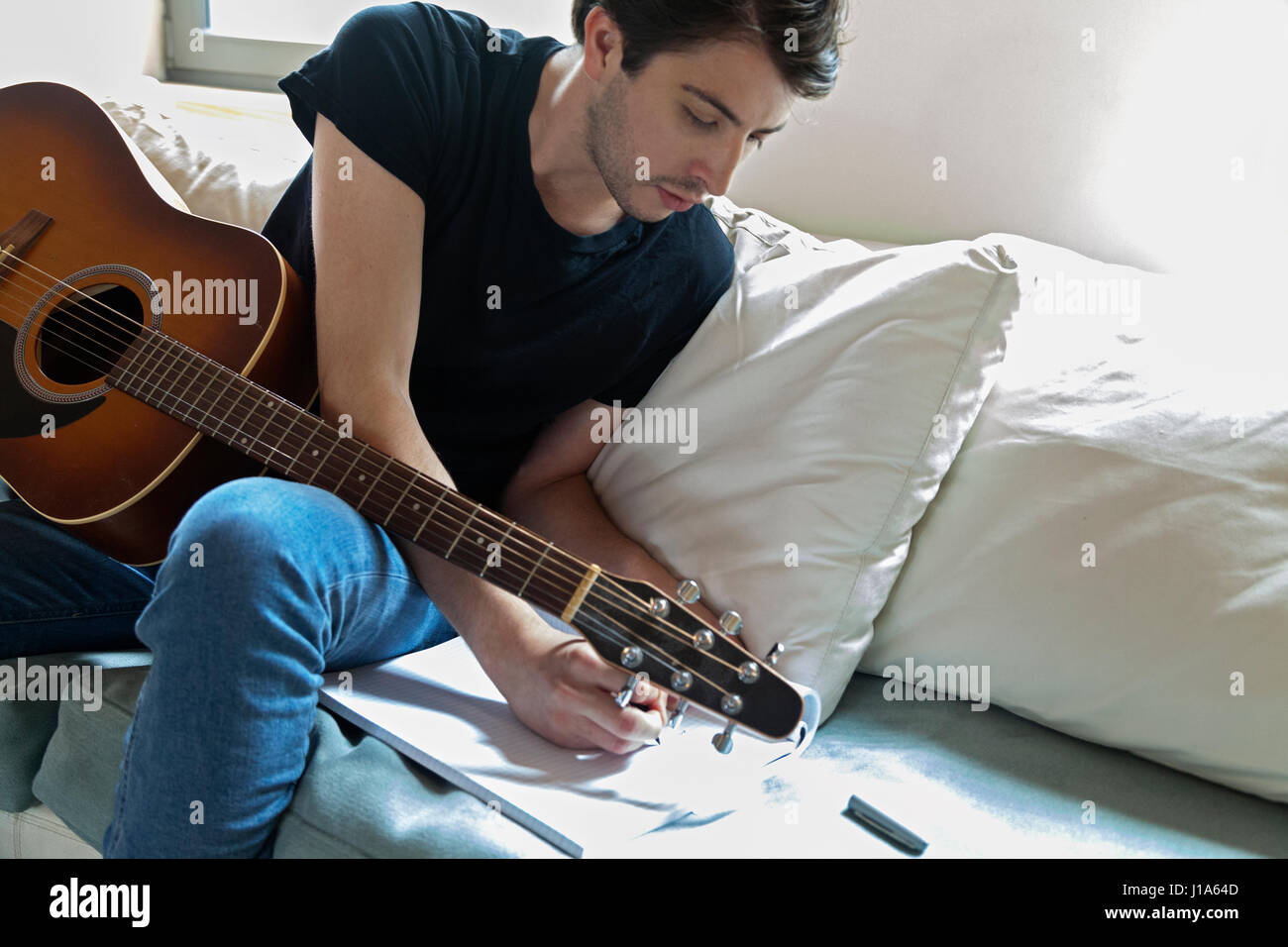 Young musician writing songs on an acoustic guitar Stock Photo Alamy