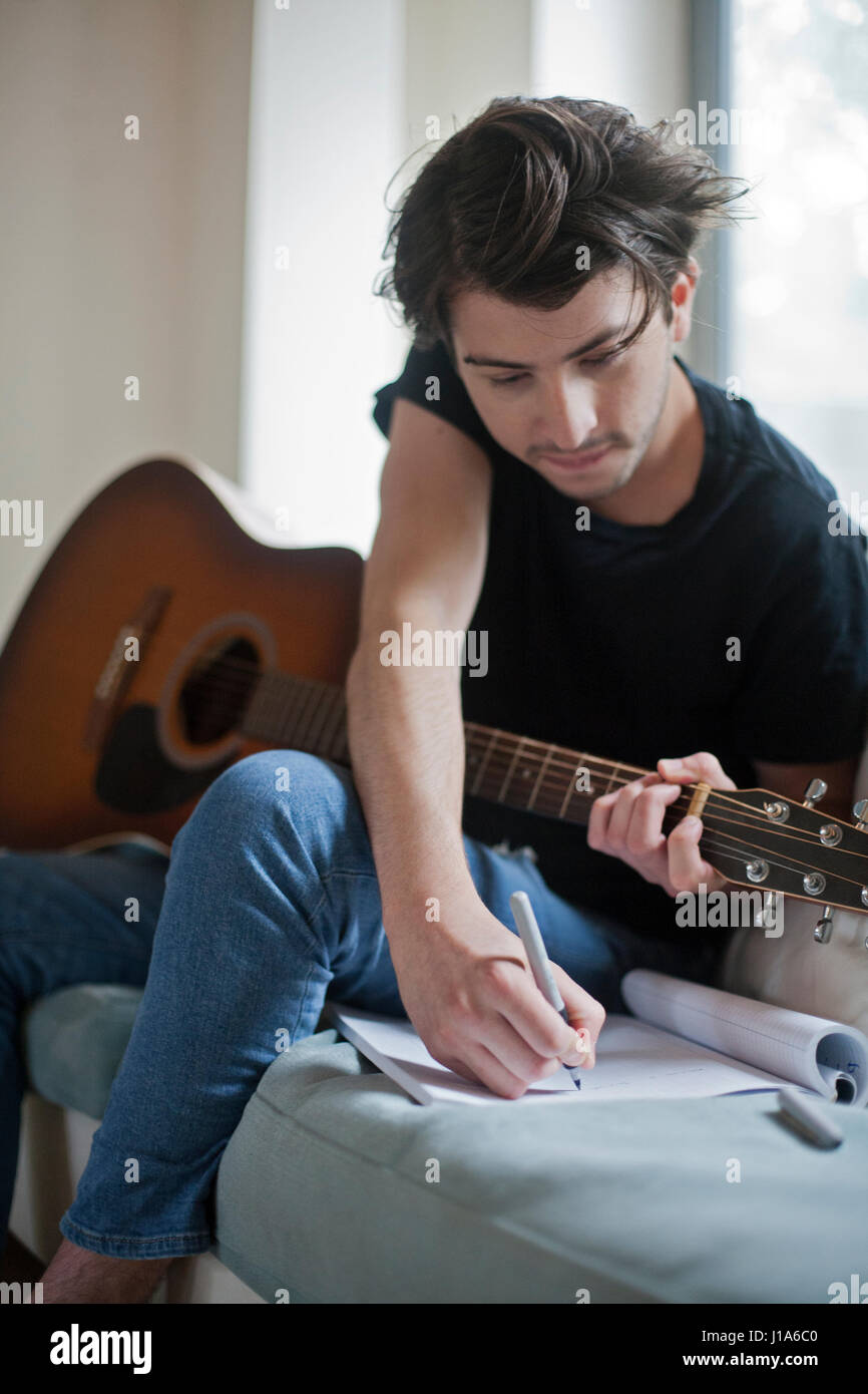 Young musician writing songs on an acoustic guitar Stock Photo Alamy