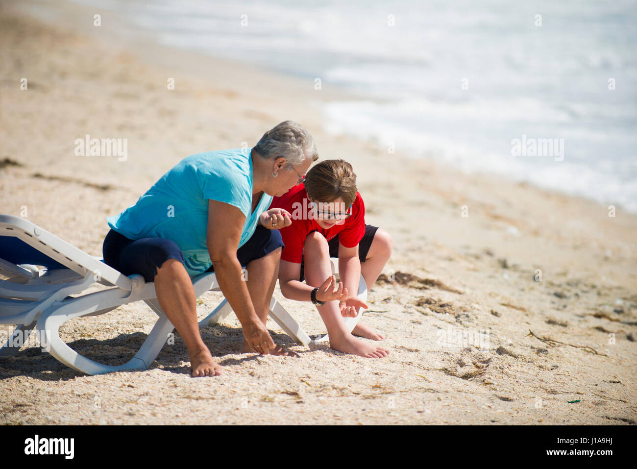 people on beach looking for sea shells Stock Photo