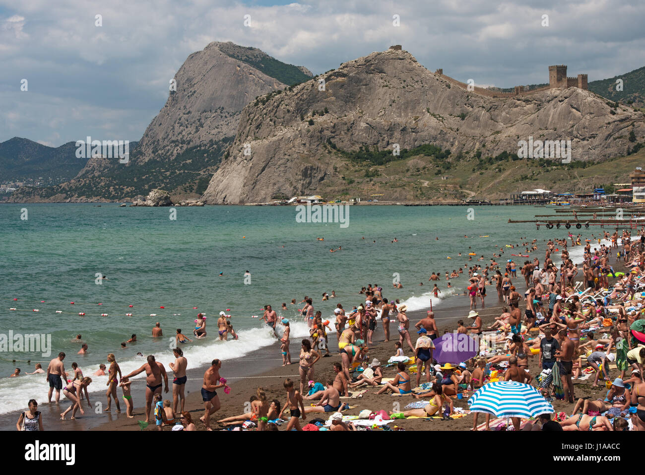 Beach of Sudak towards Genoese Fortress, Sokol Mountain and Novyi Svet (New World), Crimea, Russia. Stock Photo