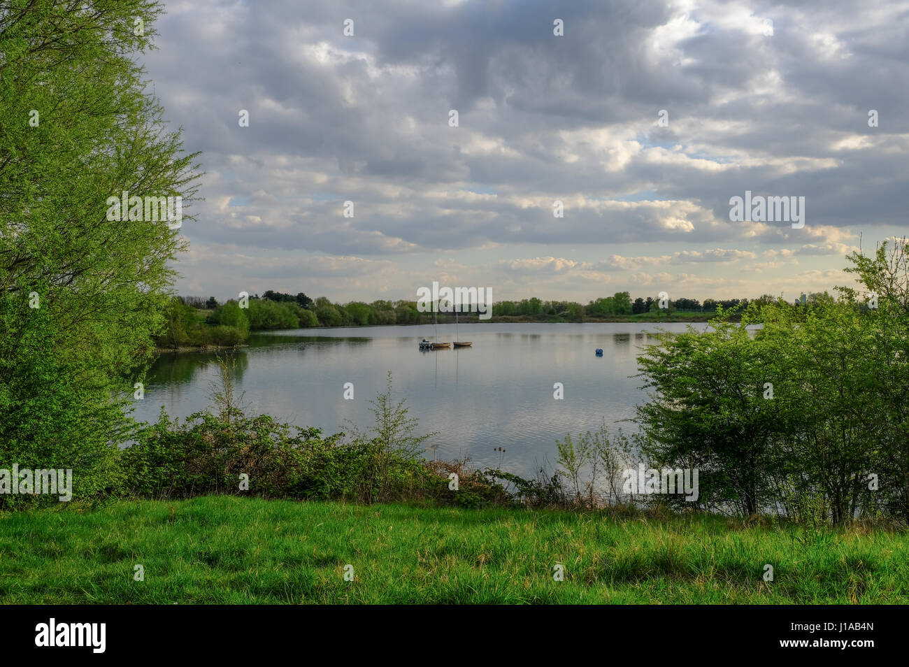 View of tranquil lake with moored boats and lovely reflections. .  Shot in springtime Stock Photo