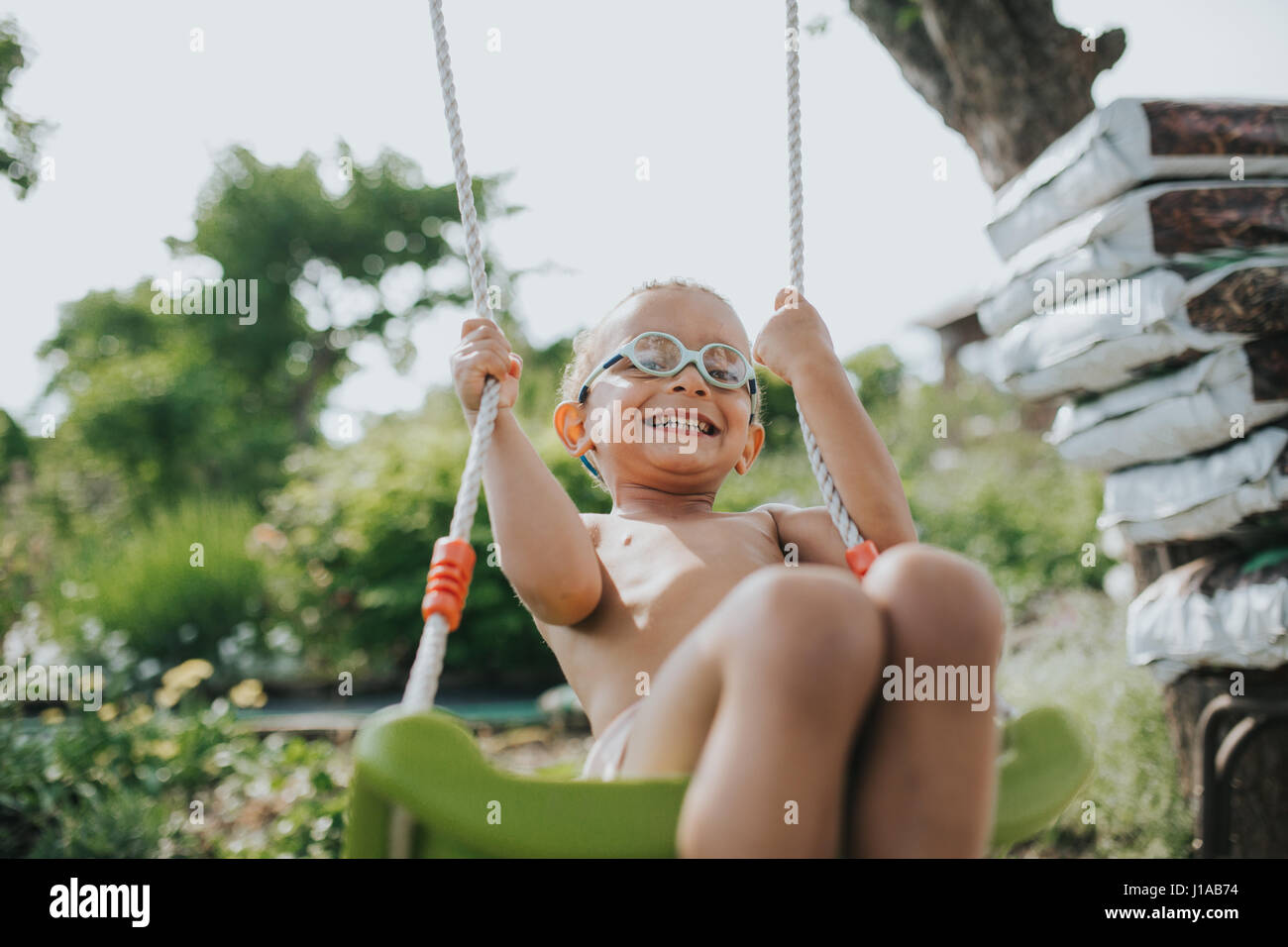young coloured boy is having fun on the swing Stock Photo