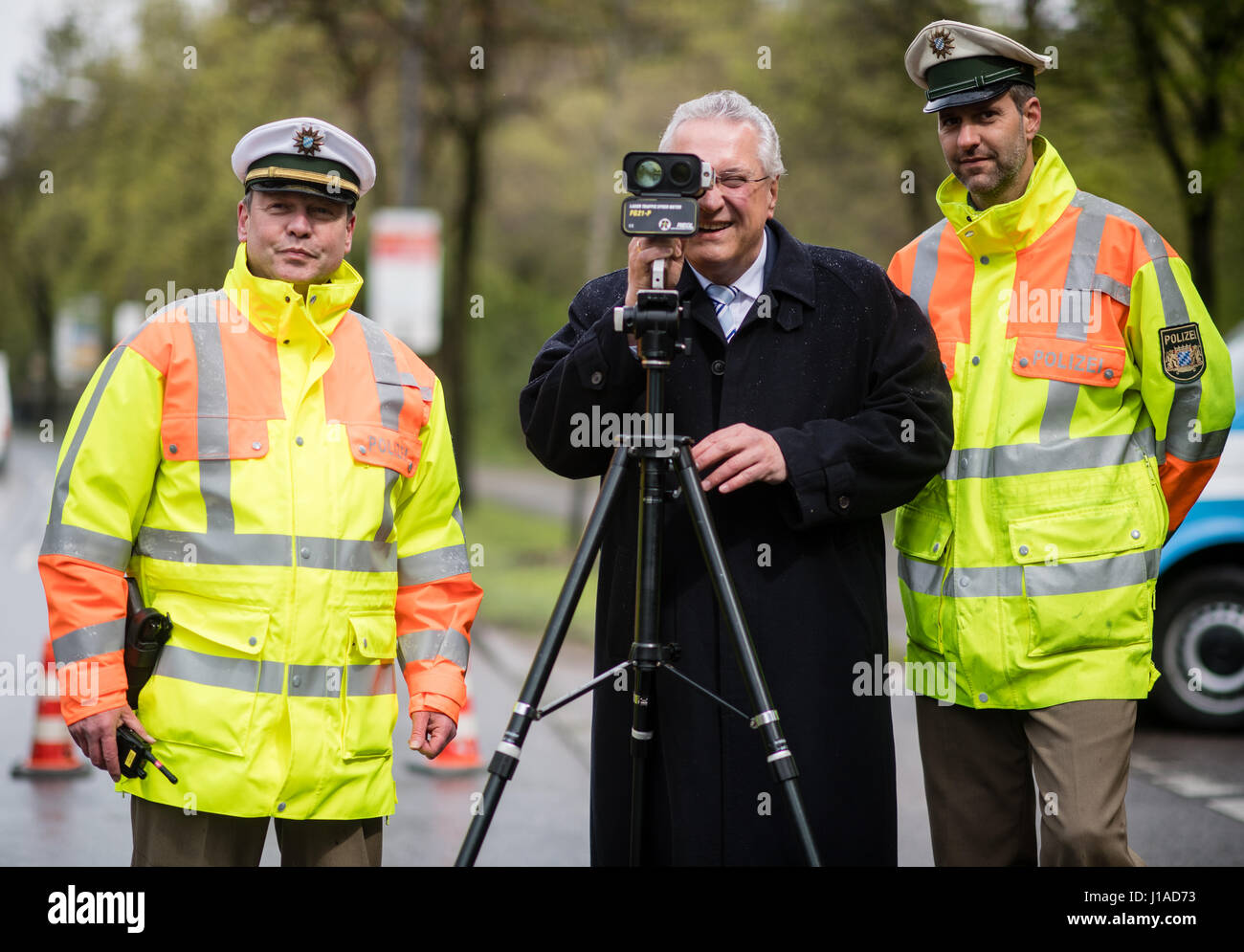 Munich, Germany. 19th Apr, 2017. Bavaria's Interior Minister Joachim Herrmann takes a look through a laser gun for measuring speed, flanked by Chief of Police Tobias Flamme and Police Chief Advisor Peter Schiller, in Munich, Germany, 19 April 2017. Police in several german states are enforcing stricter speed controls as part of a continent-wide speed control marathon. Photo: Matthias Balk/dpa/Alamy Live News Stock Photo