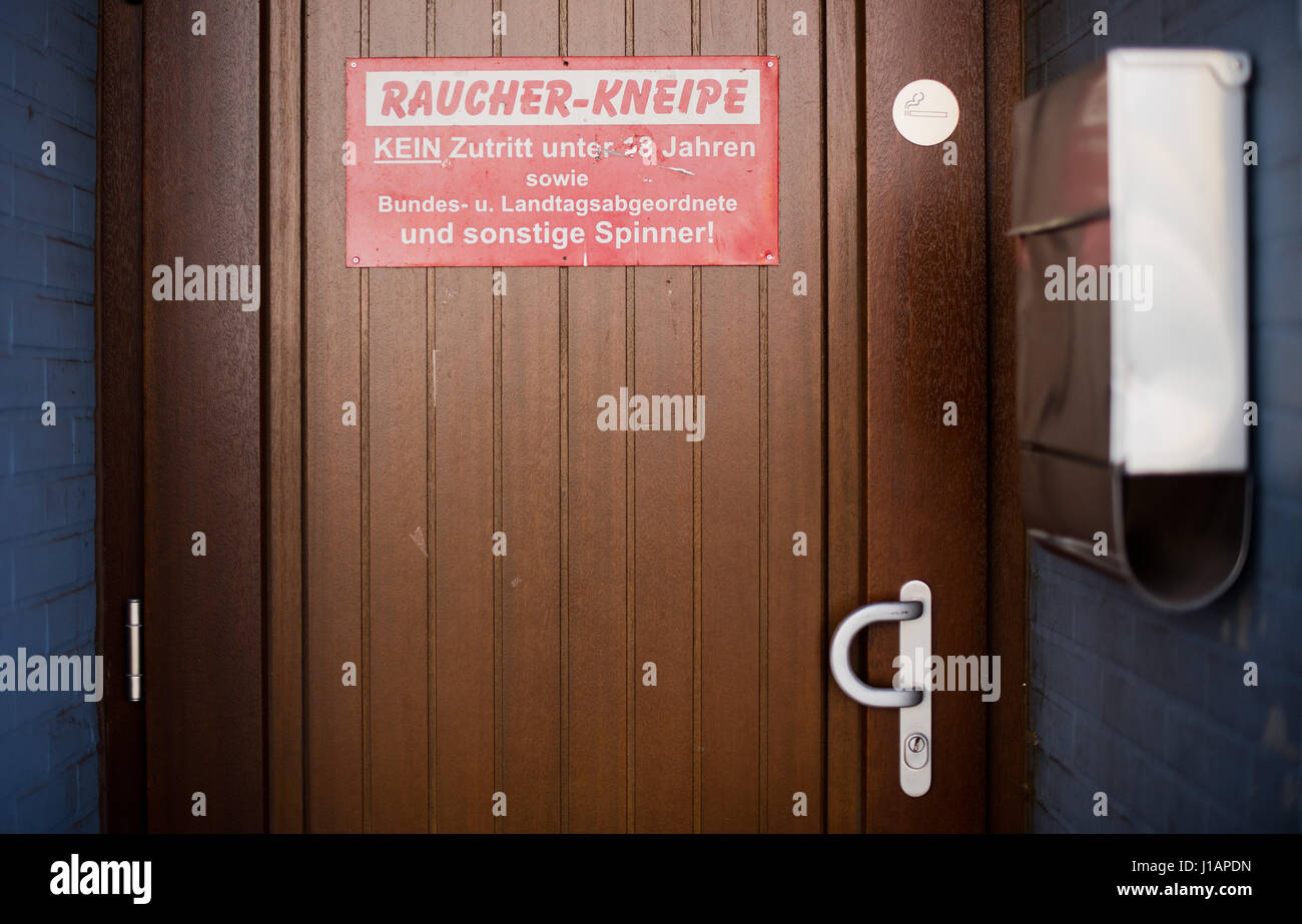 A sign reading 'Raucher-Kneipfe' (lit. 'Smokers' Pub' can be seen at a bar in Hanover, Germany, 20 April 2017. The sign forbids the entrance of people under the age of 18 as well as 'Members of the federal or state parliaments and other weirdos!'. Photo: Julian Stratenschulte/dpa Stock Photo
