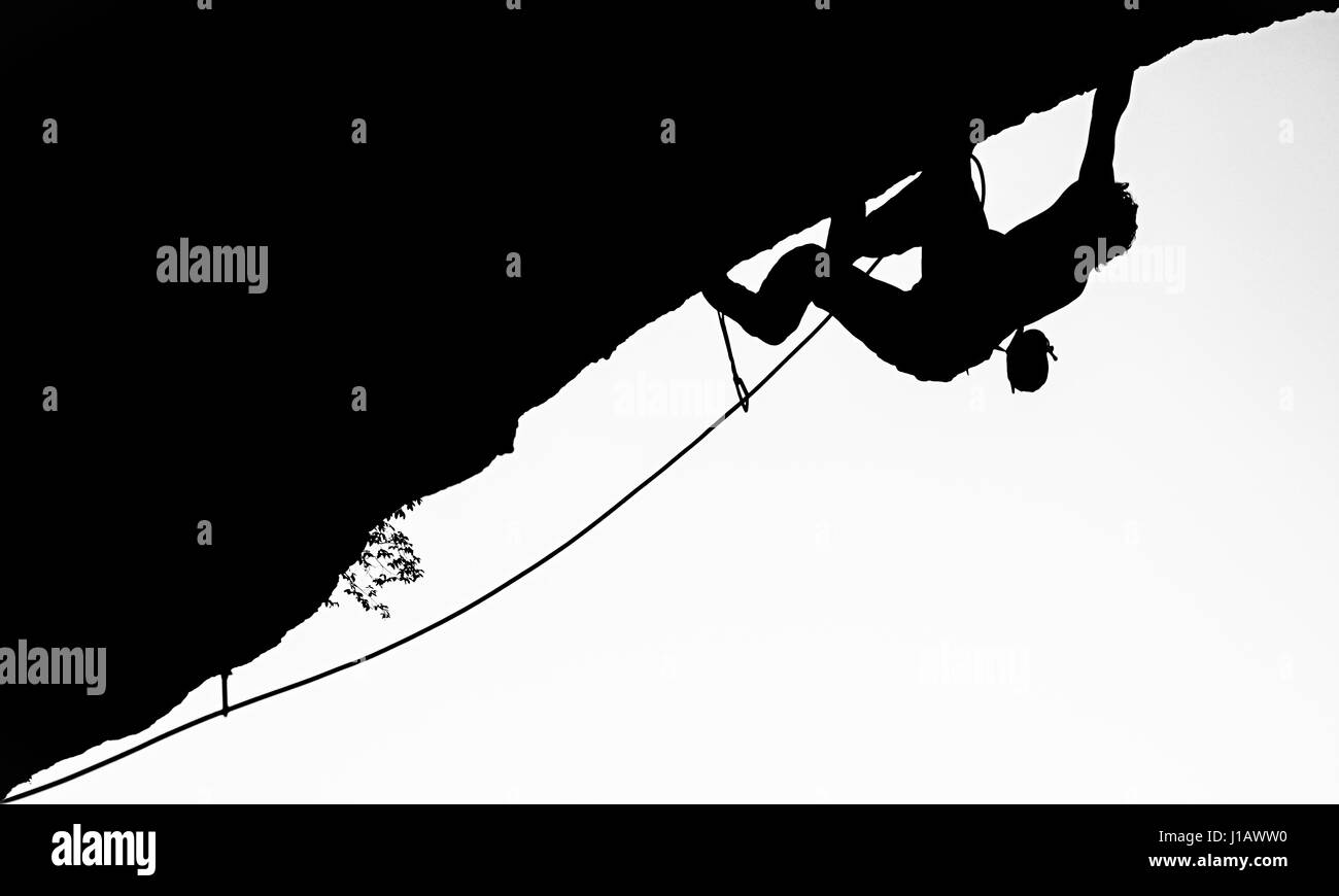 A mountain climber is hanging down from the mountain wall in Villach of