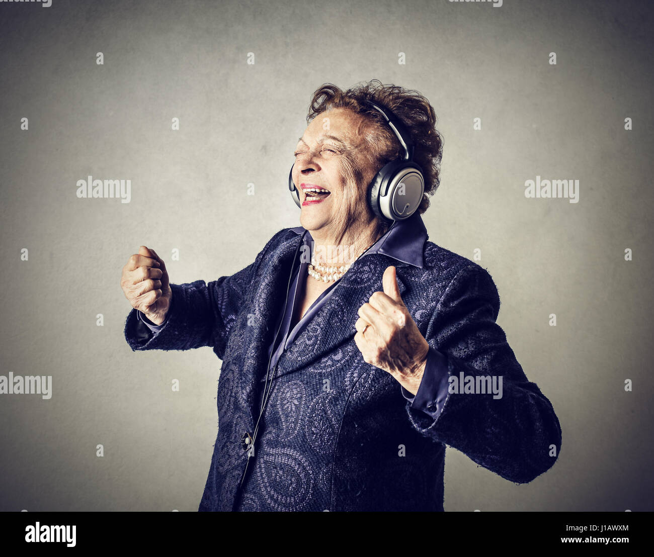 Old woman listening to music Stock Photo