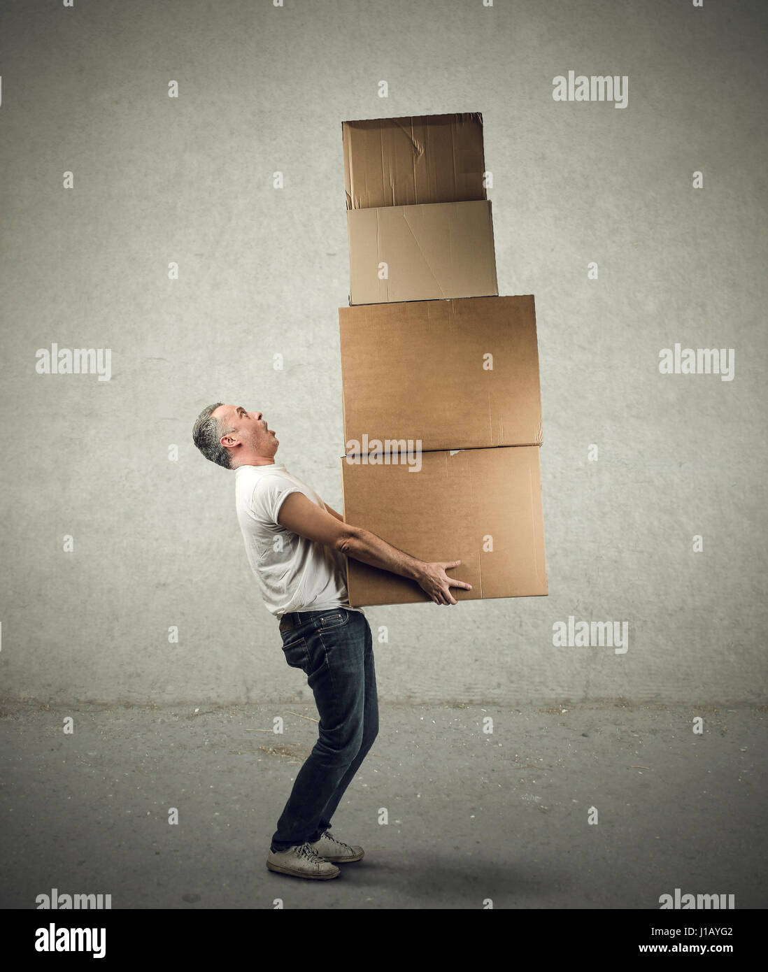 Man carrying heavy boxes Stock Photo