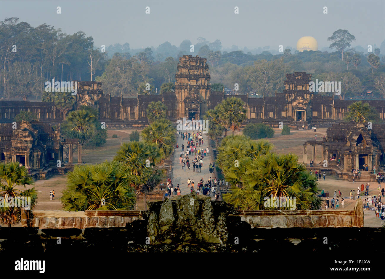 Tourists arriving to visit the religious monument of Angkor Wat by way of the causeway, in Siem Reap, Cambodia. Stock Photo