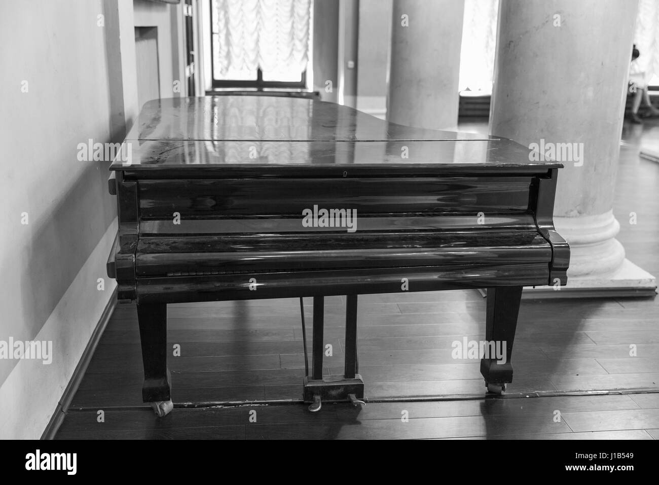 Old black grand piano closeup indoor in conservatory, black and white Stock Photo
