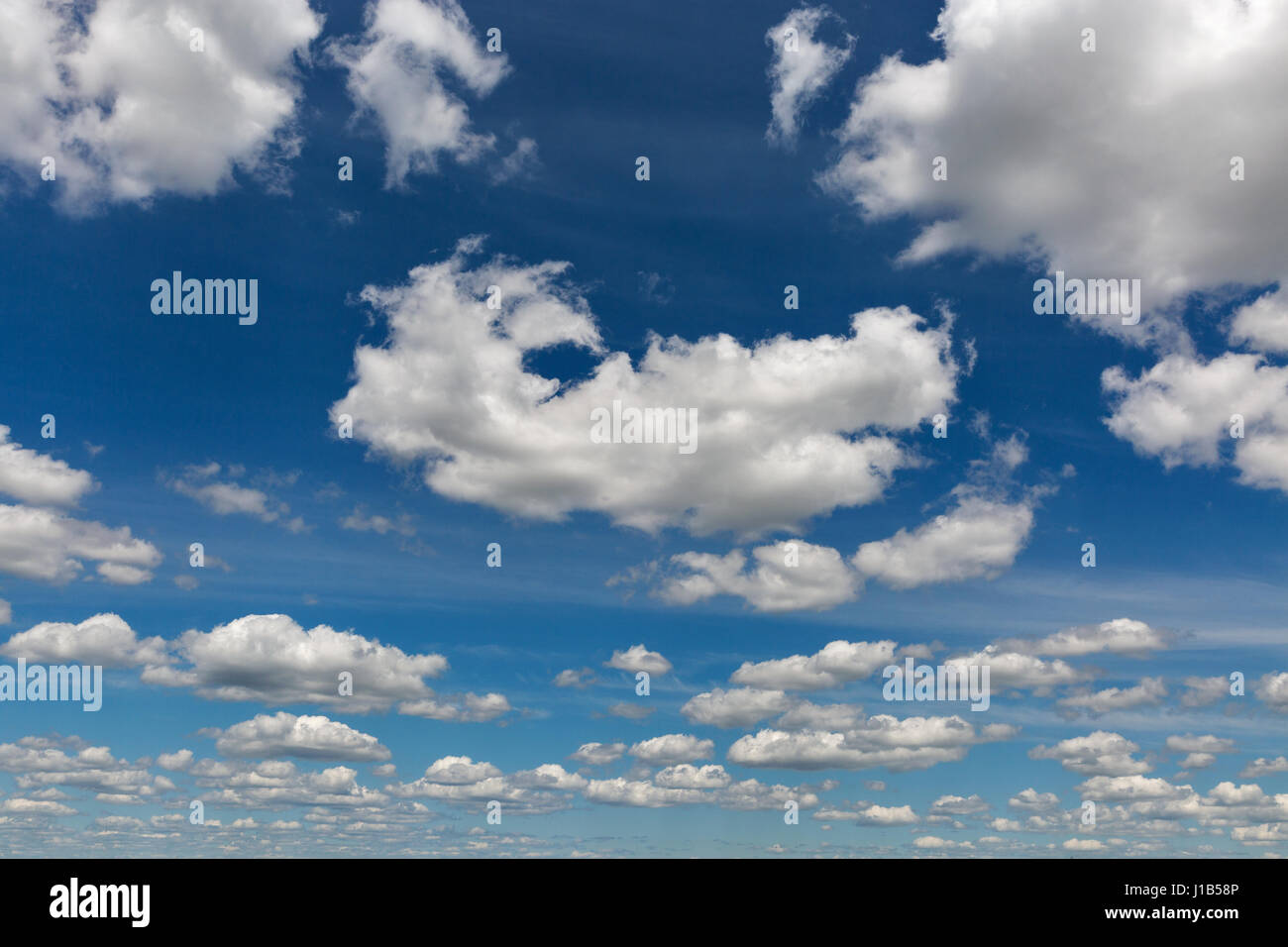 Cloudscape with white clouds against clear and blue sky Stock Photo - Alamy