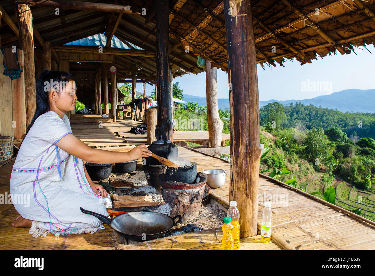 Asian woman cooking on patio outdoors Stock Photo