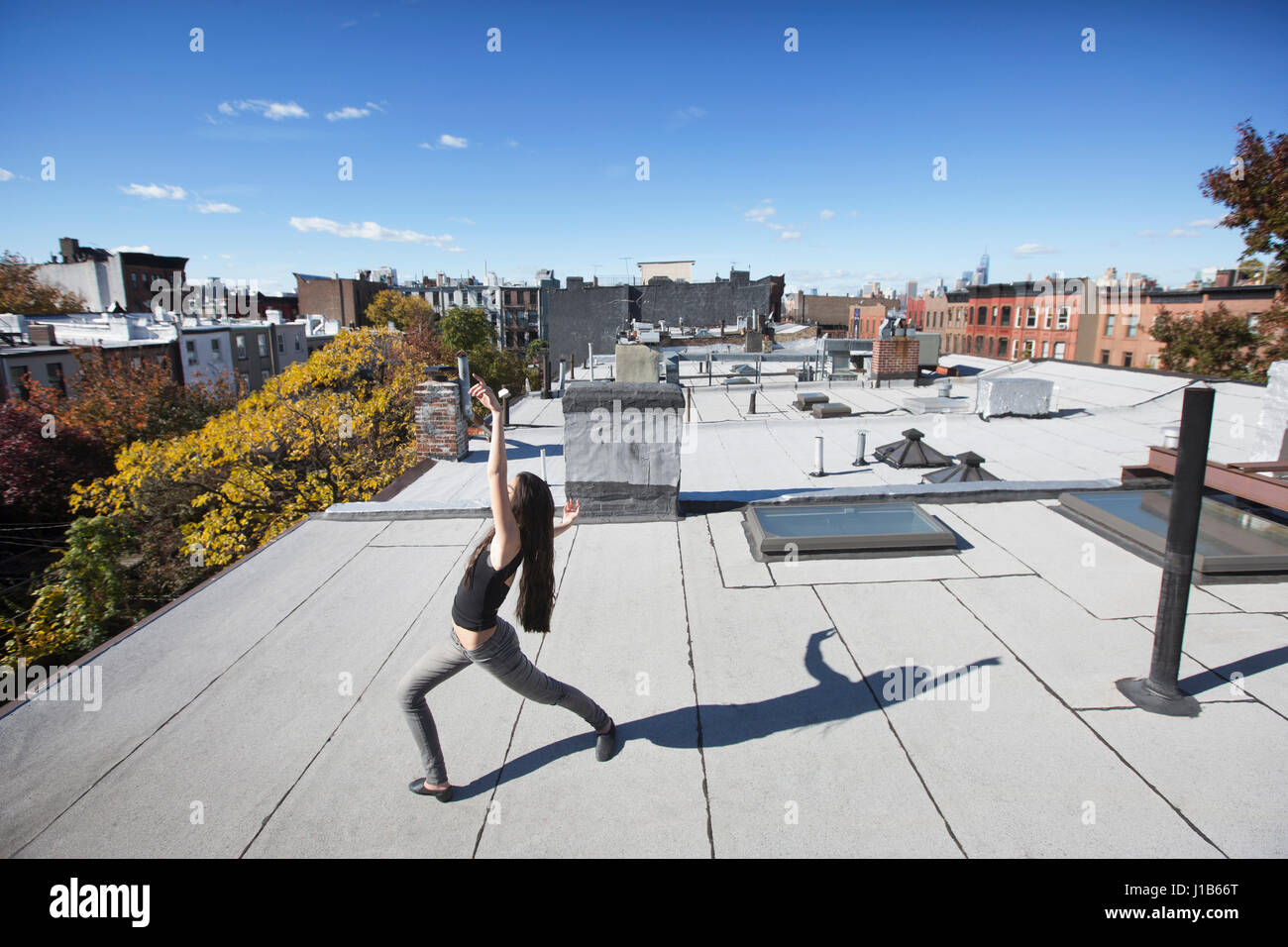 Caucasian girl dancing on rooftop Stock Photo