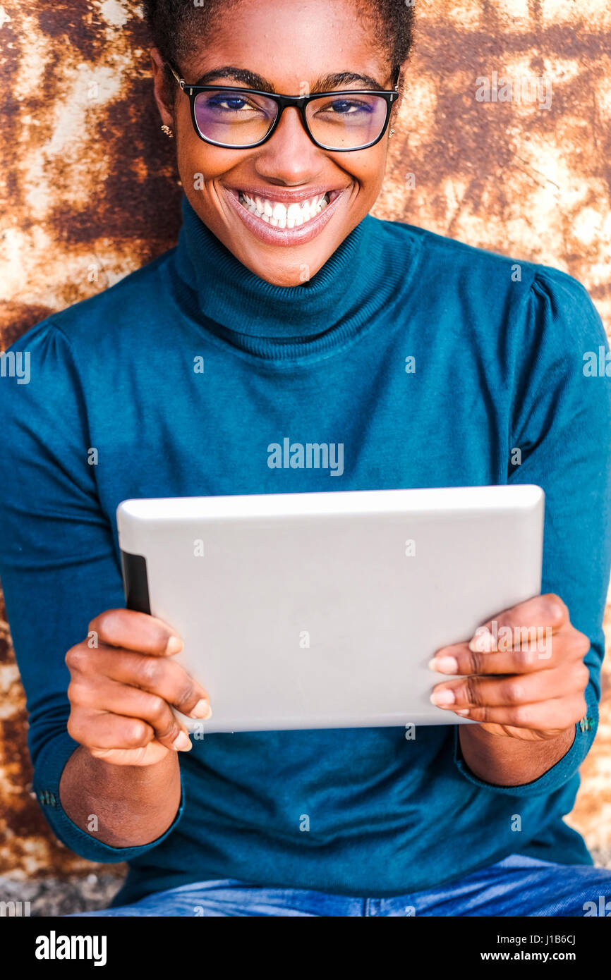 Smiling African American woman holding digital tablet Stock Photo