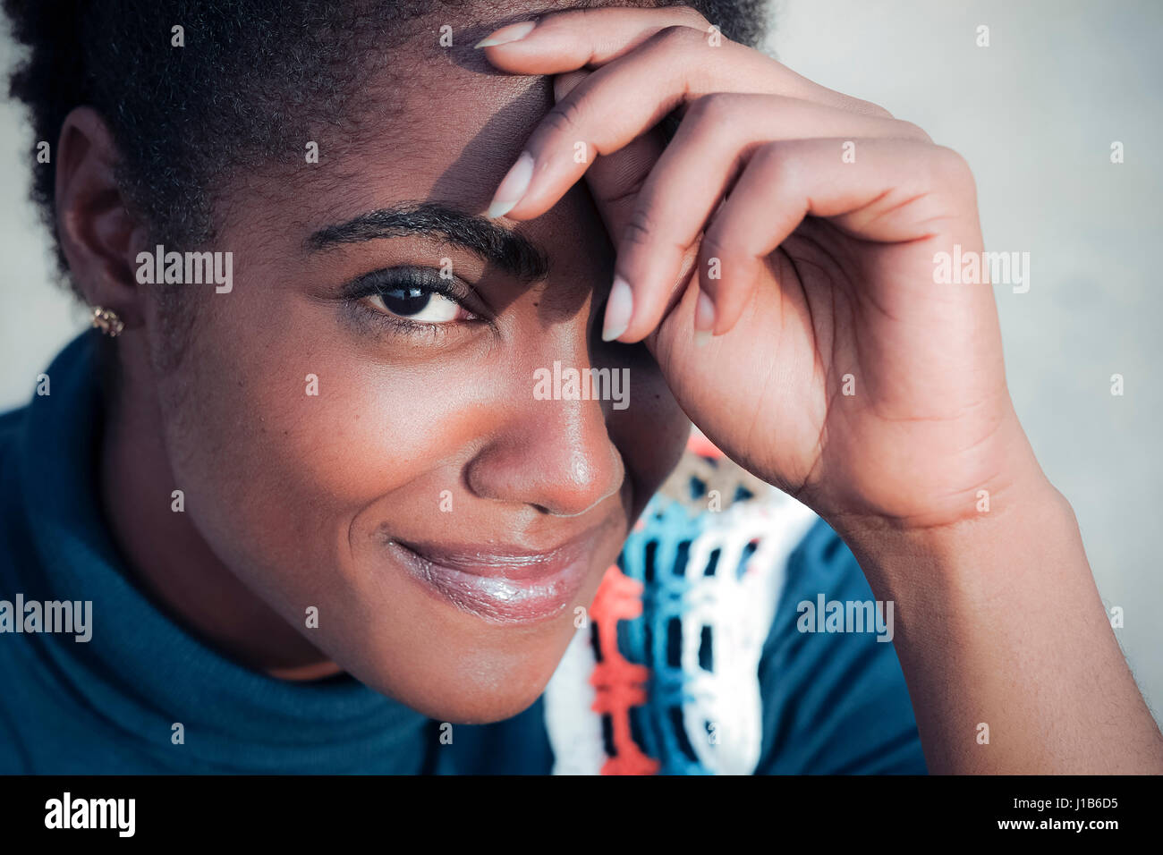 Smiling African American woman with hand on forehead Stock Photo