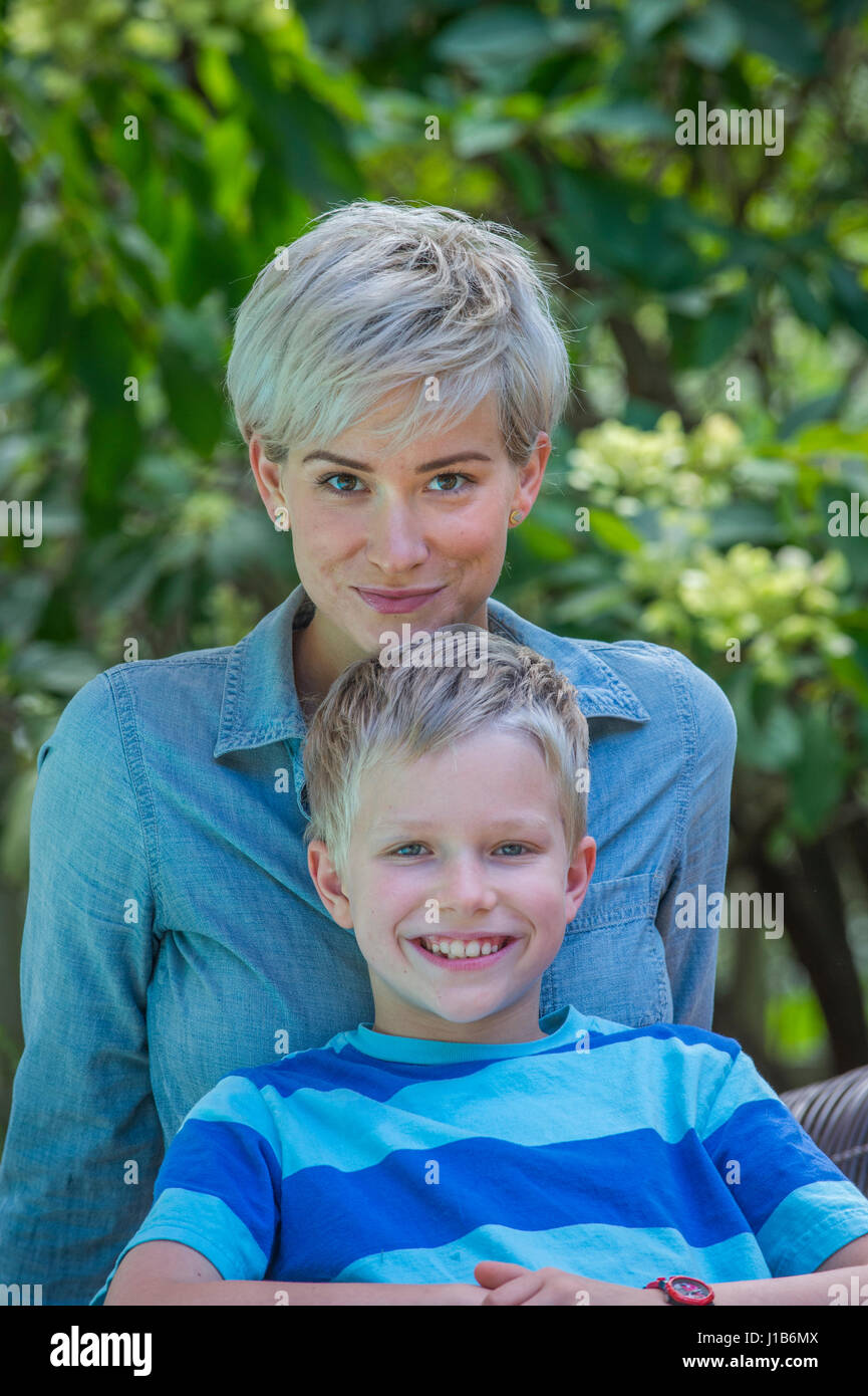 Caucasian boy leaning on mother outdoors Stock Photo