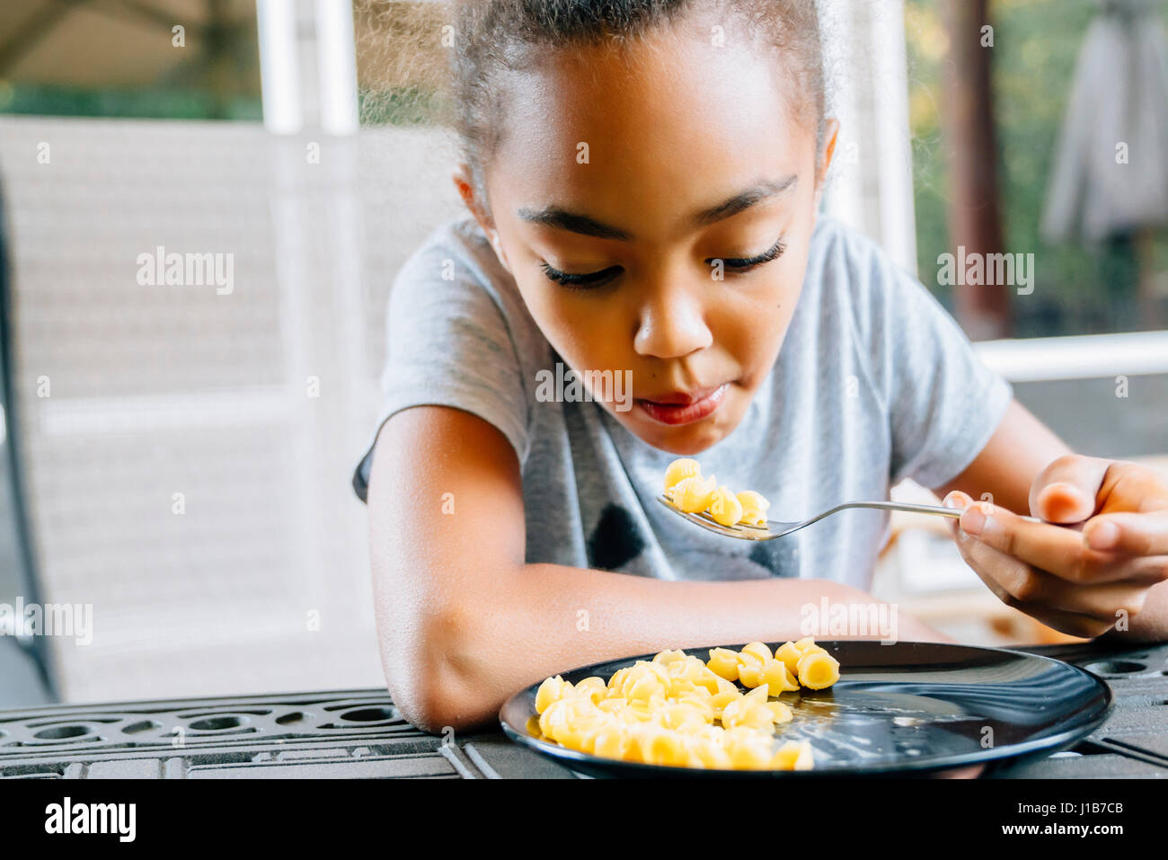 Mixed Race girl eating food with fork Stock Photo