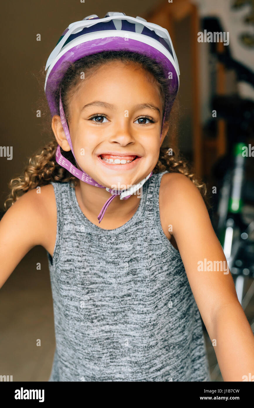 Portrait of smiling Mixed Race girl wearing helmet Stock Photo