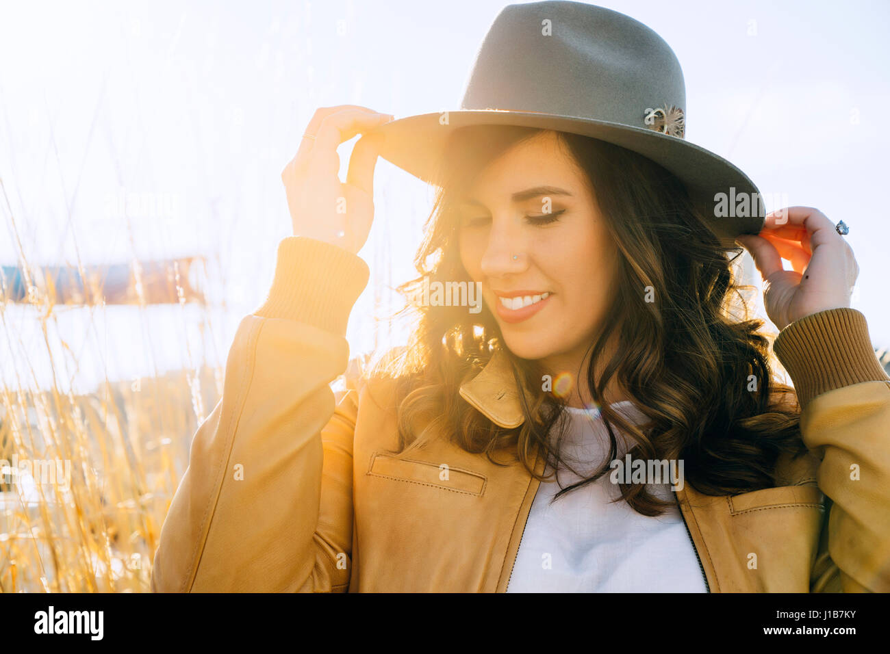 Portrait of smiling Mixed Race woman adjusting hat Stock Photo