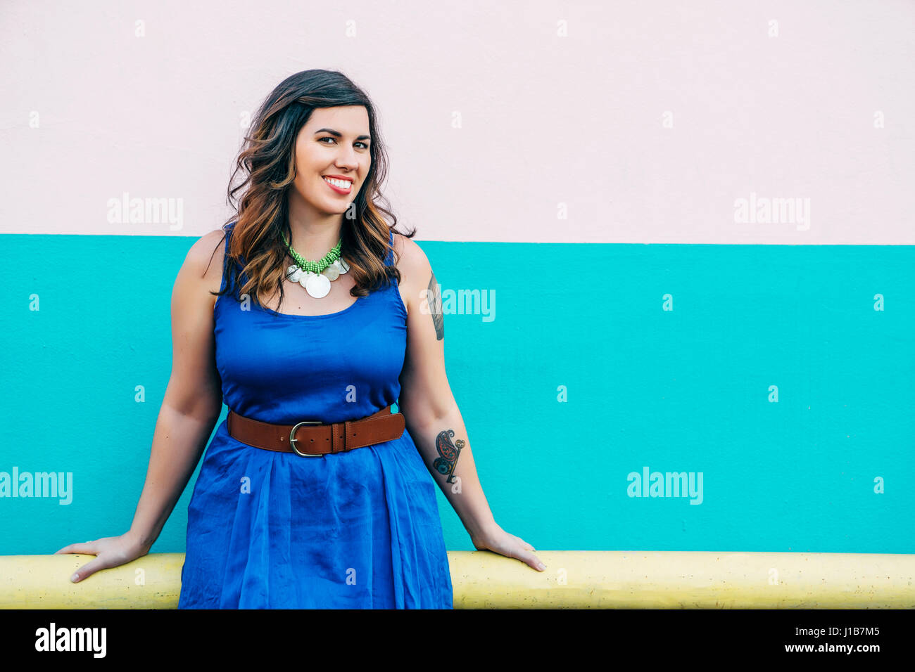 Portrait of smiling Mixed Race woman wearing blue dress Stock Photo