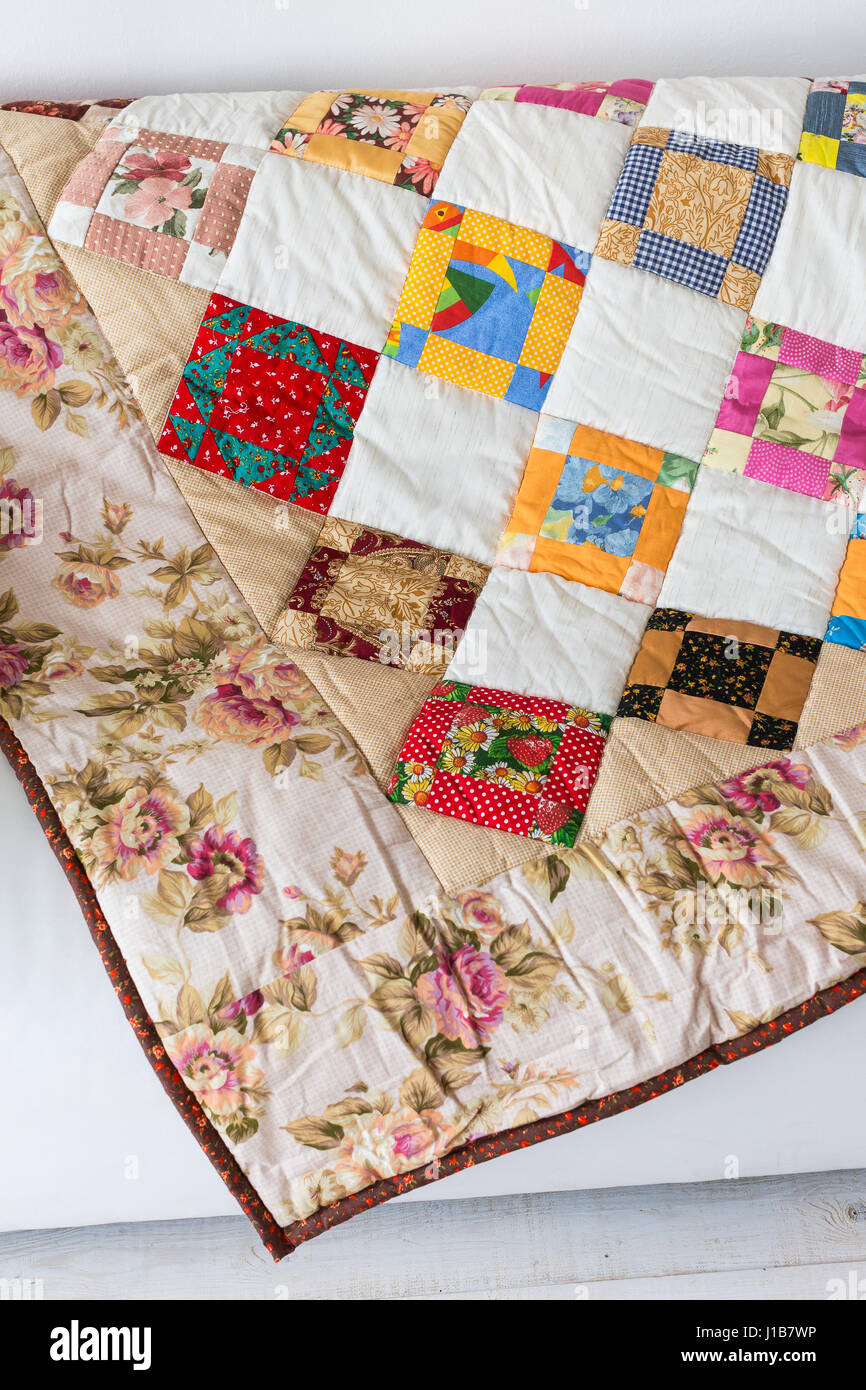 Part of color patchwork quilt with vintage flowers pattern lying on a ...