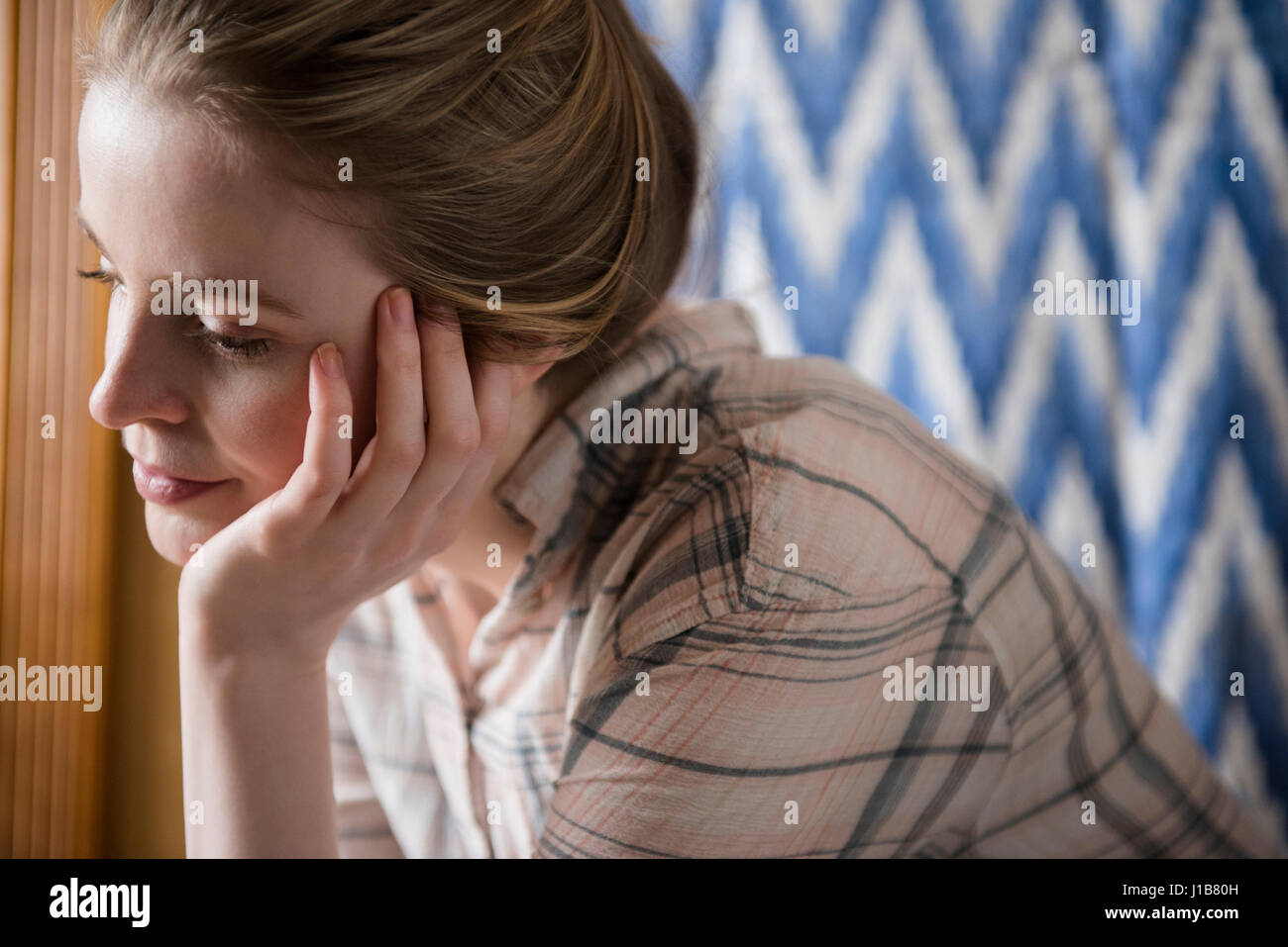 Pensive woman with hand on chin Stock Photo