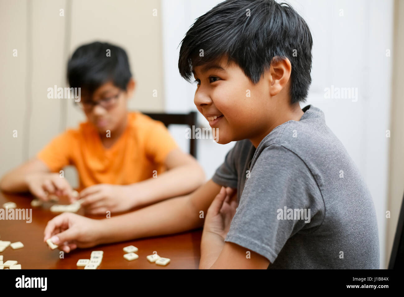 Native American boys playing spelling game at table Stock Photo