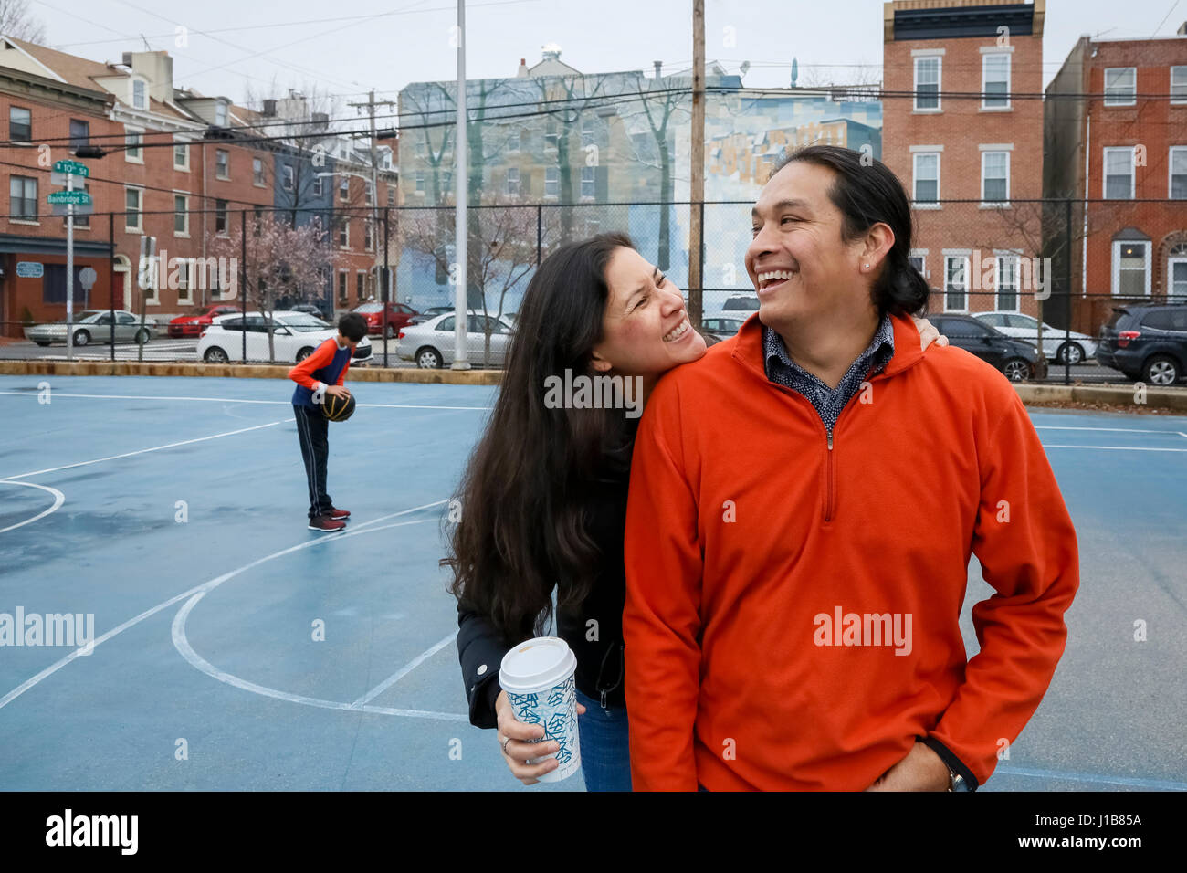 Couple smiling on urban basketball court Stock Photo