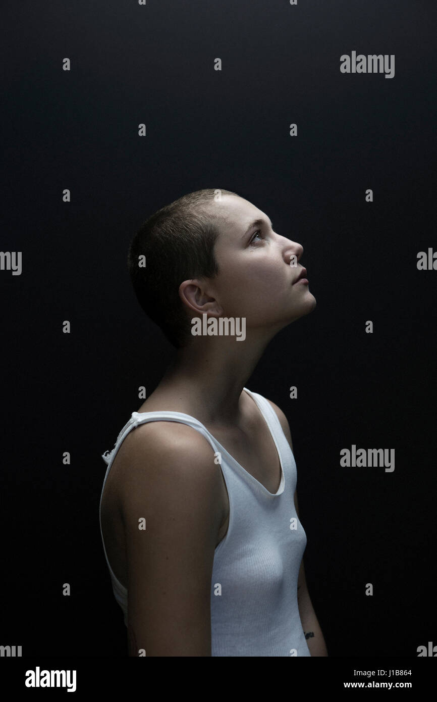 Caucasian woman with shaved-head looking up Stock Photo