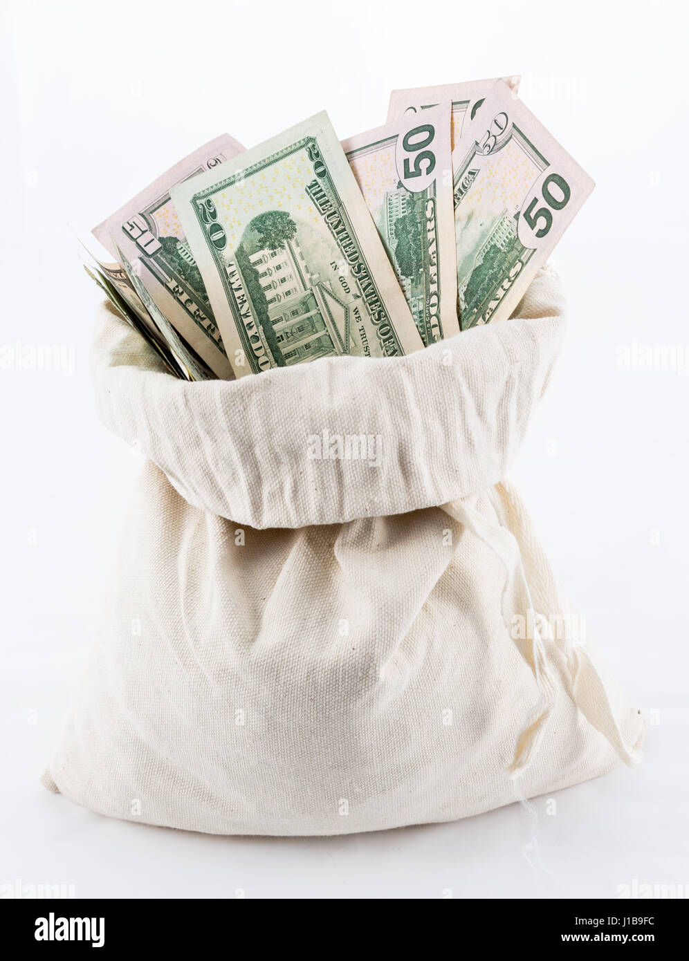 Sack of money - thousands of US dollars / dollar bill notes in a money bag on a white background Stock Photo