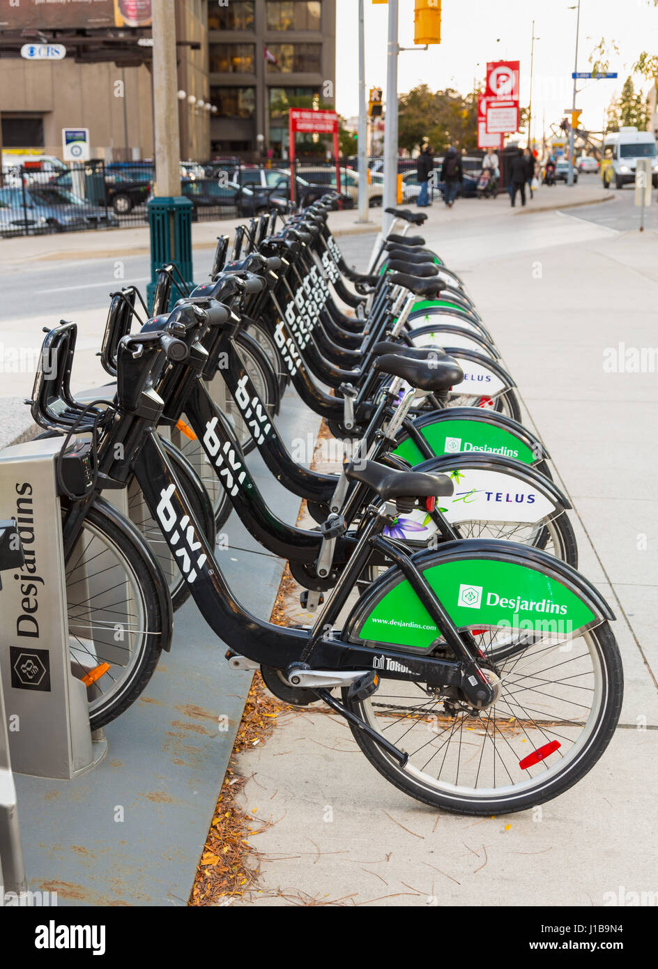 Row of bike share cycle rental bicycles sponsored by Desjardins and Telus on the streets of Toronto in Ontario, Canada. Stock Photo