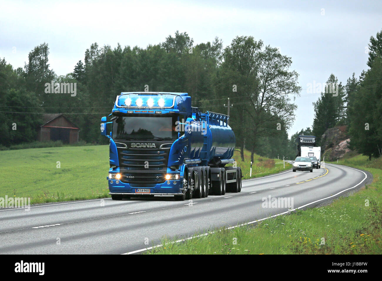 TENHOLA, FINLAND - JULY 22, 2016: New blue Scania R580 tank truck for bulk transport on summer highway in South of Finland. The driver flashes the hig Stock Photo