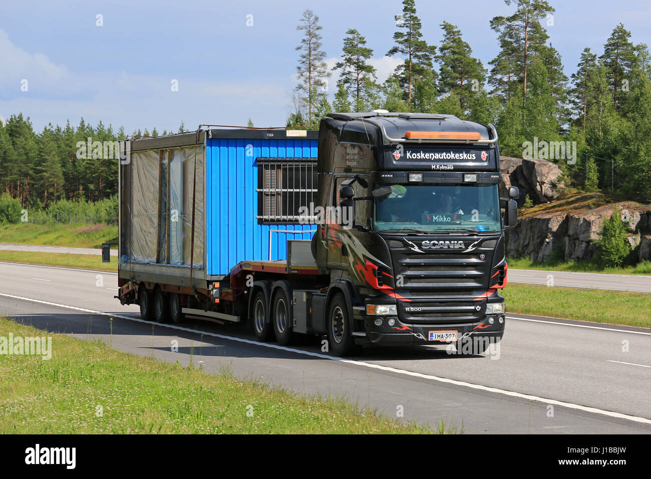 PAIMIO, FINLAND - JULY 1, 2016: Scania R500 truck transports portable cabin along motorway at summer. Portable cabins are often used as as temporary o Stock Photo