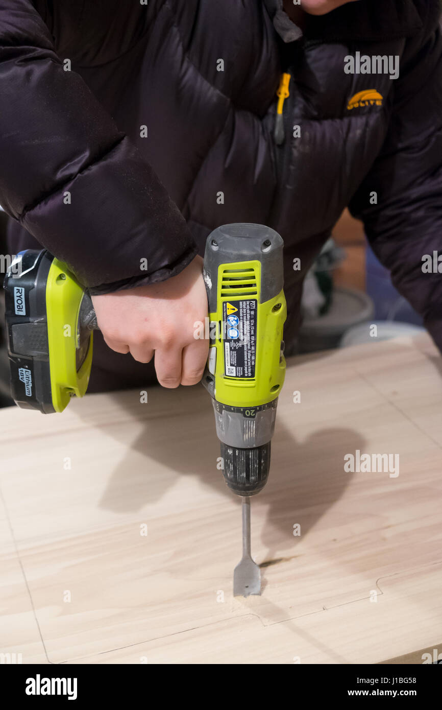 SPRINGFIELD, OR - JANUARY 31, 2017: Ryobi drill/driver tool being used on a piece of wood during a major DIY house renovation project. Stock Photo