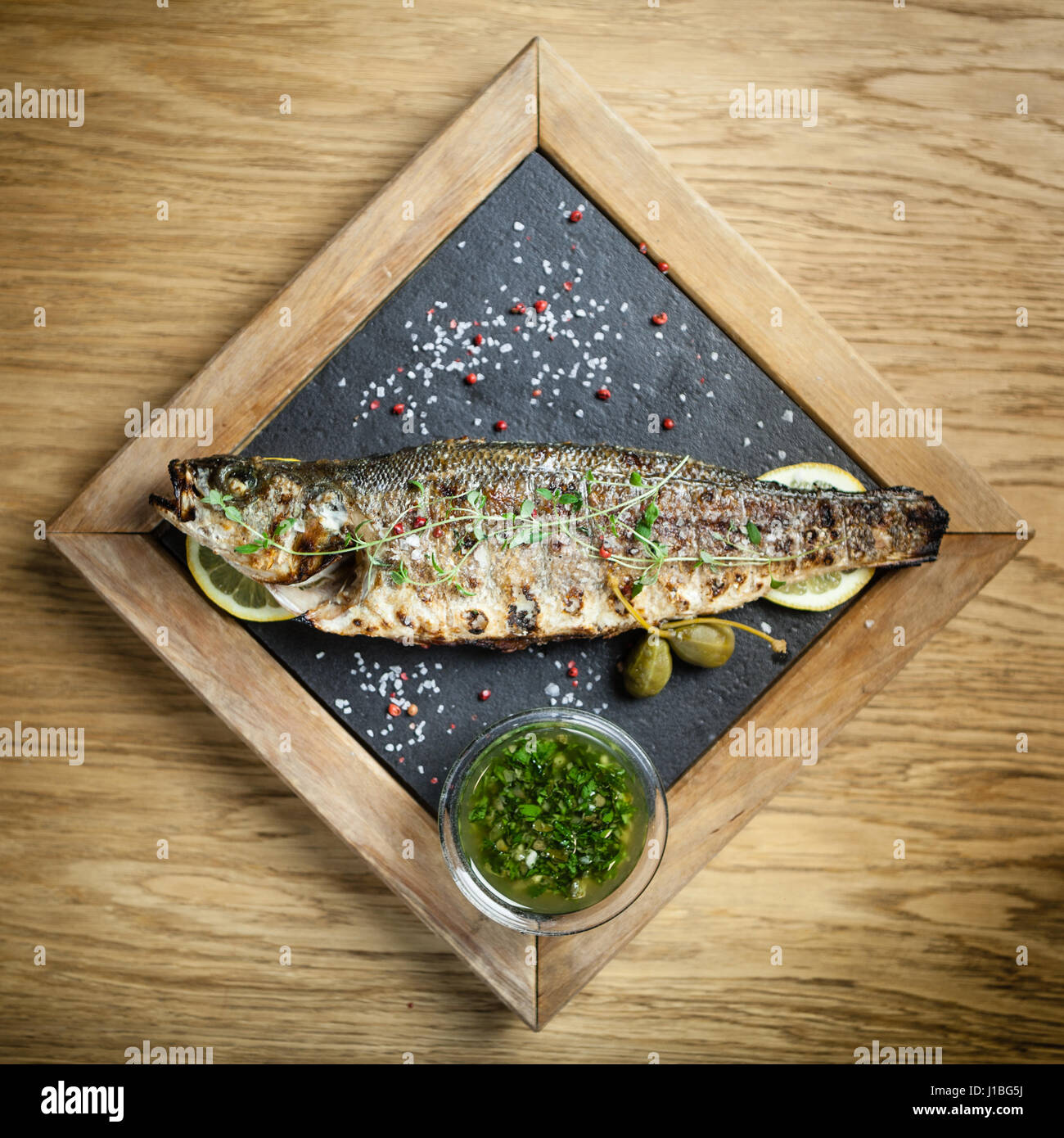 Fresh sea bass. Mediterranean fish, baked entirely in a coal stove with
