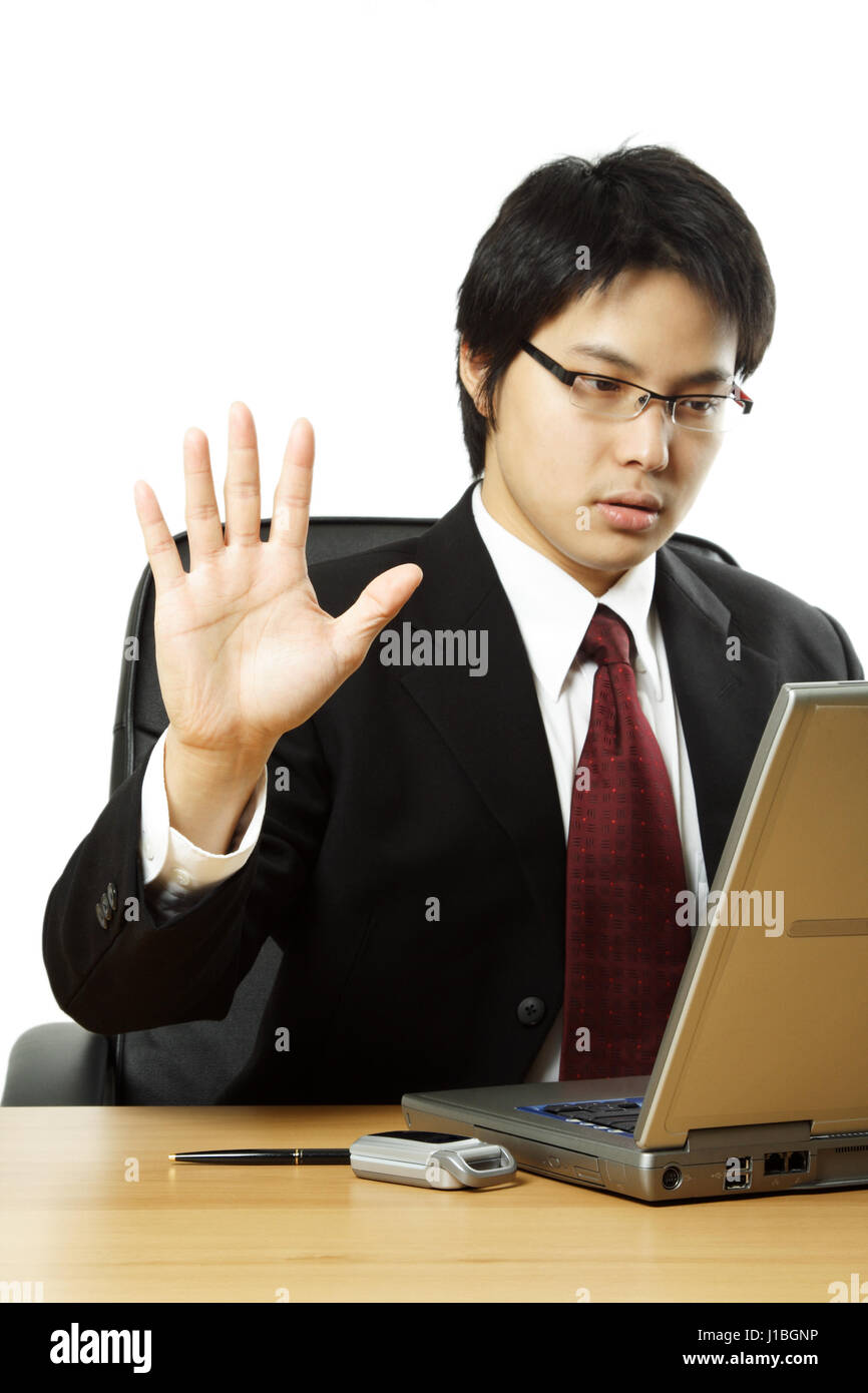 A businessman working on his laptop with his hand up Stock Photo - Alamy